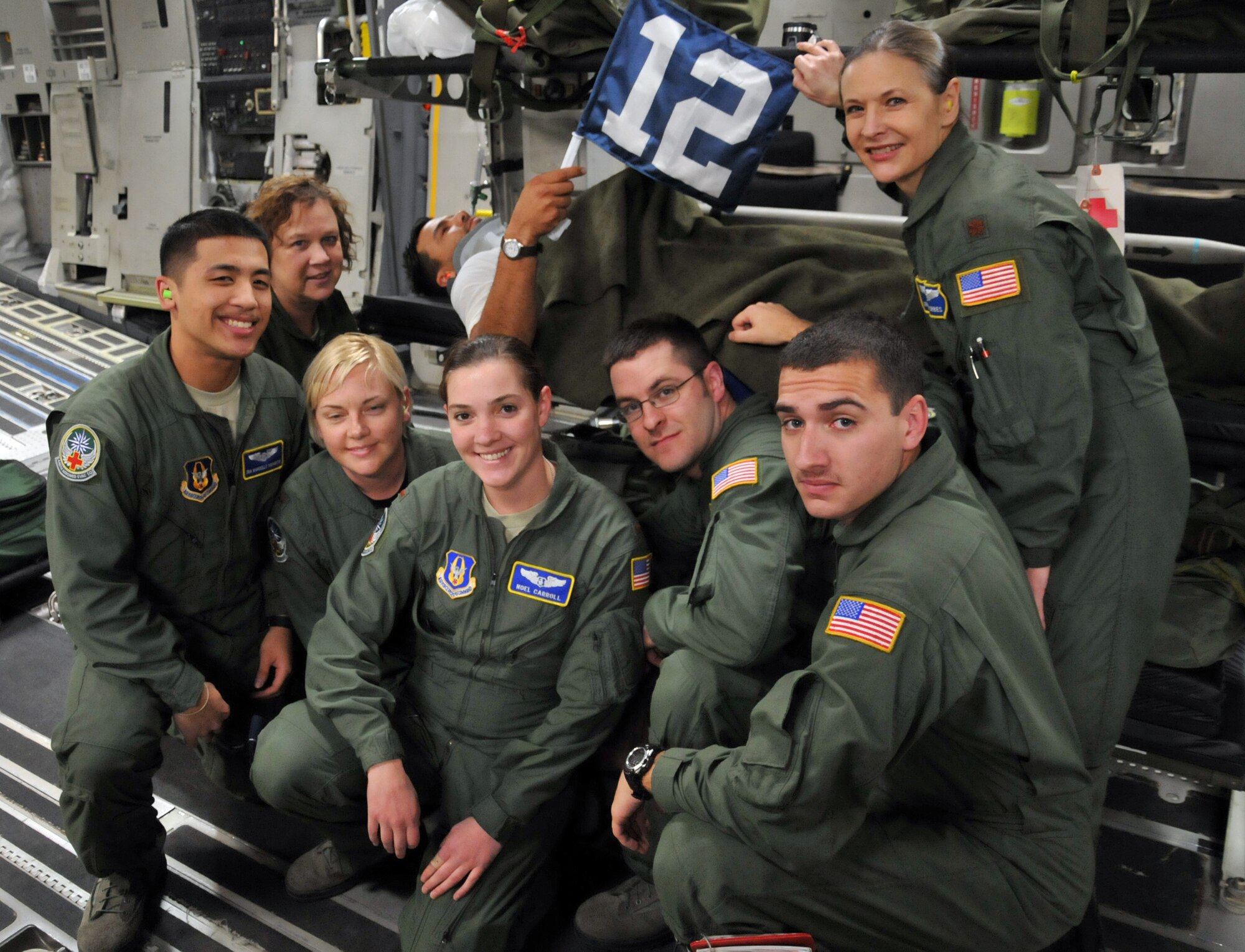 JOINT BASE PEARL HARBOR-HICKAM, Hawaii- Reservists with the 446th Aeromedical Evacuation Squadron out of McChord Field, Wash. take a moment to appreciate the Seattle Seahawks' Spirit of the 12th Man during a training mission here. Capt. Lee Wilkerson, a KC-135 Stratotanker pilot from Spokane, Wash., who injured his neck in Hawaii, helps the crew with "raising" the 12th Man flag. The concept is a way of letting the Seahawks' organization know how much the 446th Airlift Wing appreciates the support that the organization has for the military and how that support is felt with the Reservists serving all over the world. (U.S. Air Force photo/Master Sgt. Jake Chappelle)
