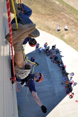 Staff Sgt. Christopher Dooley and John Mason, 14th Civil Engineer Squadron Fire Protection Services Flight, demonstrate backwards repelling at the 2010 Fire Prevention Week Open House Oct. 2. (U.S. Air Force photo/Staff Sgt. Jacob Corbin). 