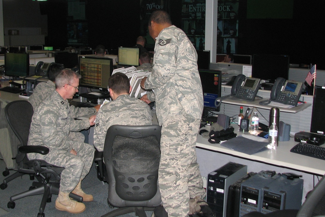 Chap. (Capt.) John M. Boulware, 480th Intelligence, Surveillance and Reconnaissance Wing chaplain, Langley Air Force Base, Va., reviews the Wing Operations Center schedule with crew members before they begin their shift.  The chaplain provides visible spiritual support to the Airmen. (U.S. Air Force photo/Ms. Mica R. Mitchell) 