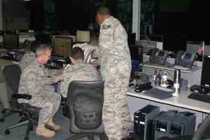 Chap. (Capt.) John M. Boulware, 480th Intelligence, Surveillance and Reconnaissance Wing chaplain, Langley Air Force Base, Va., reviews the Wing Operations Center schedule with crew members before they begin their shift.  The chaplain provides visible spiritual support to the Airmen. (U.S. Air Force photo/Ms. Mica R. Mitchell) 