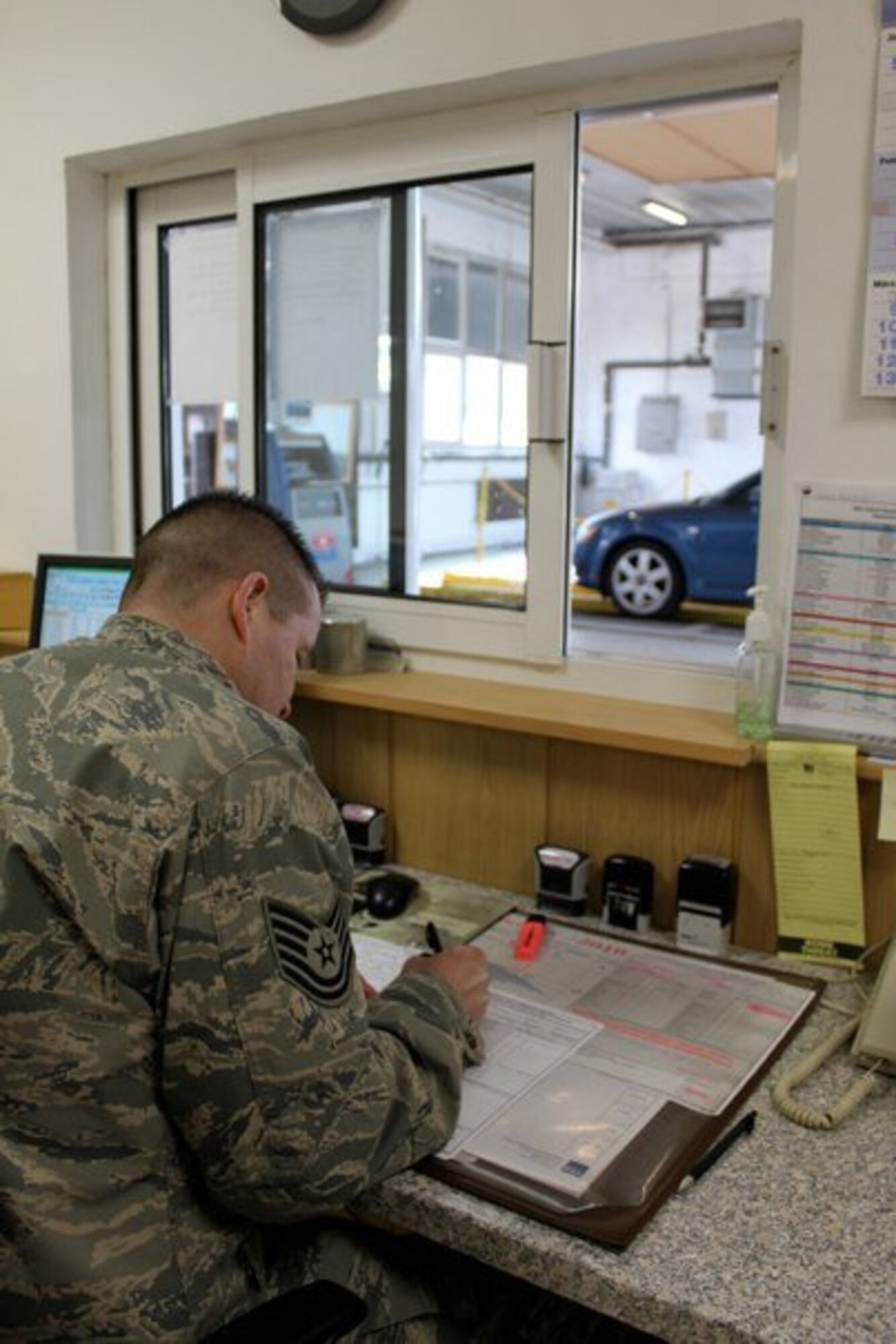 Tech. Sgt. Jerry Emry, NCOIC Kapaun POV inspection station fills out
paperwork associated with the POV inspection process. (Photo taken by Staff
Sgt. Thomas Kessler)
