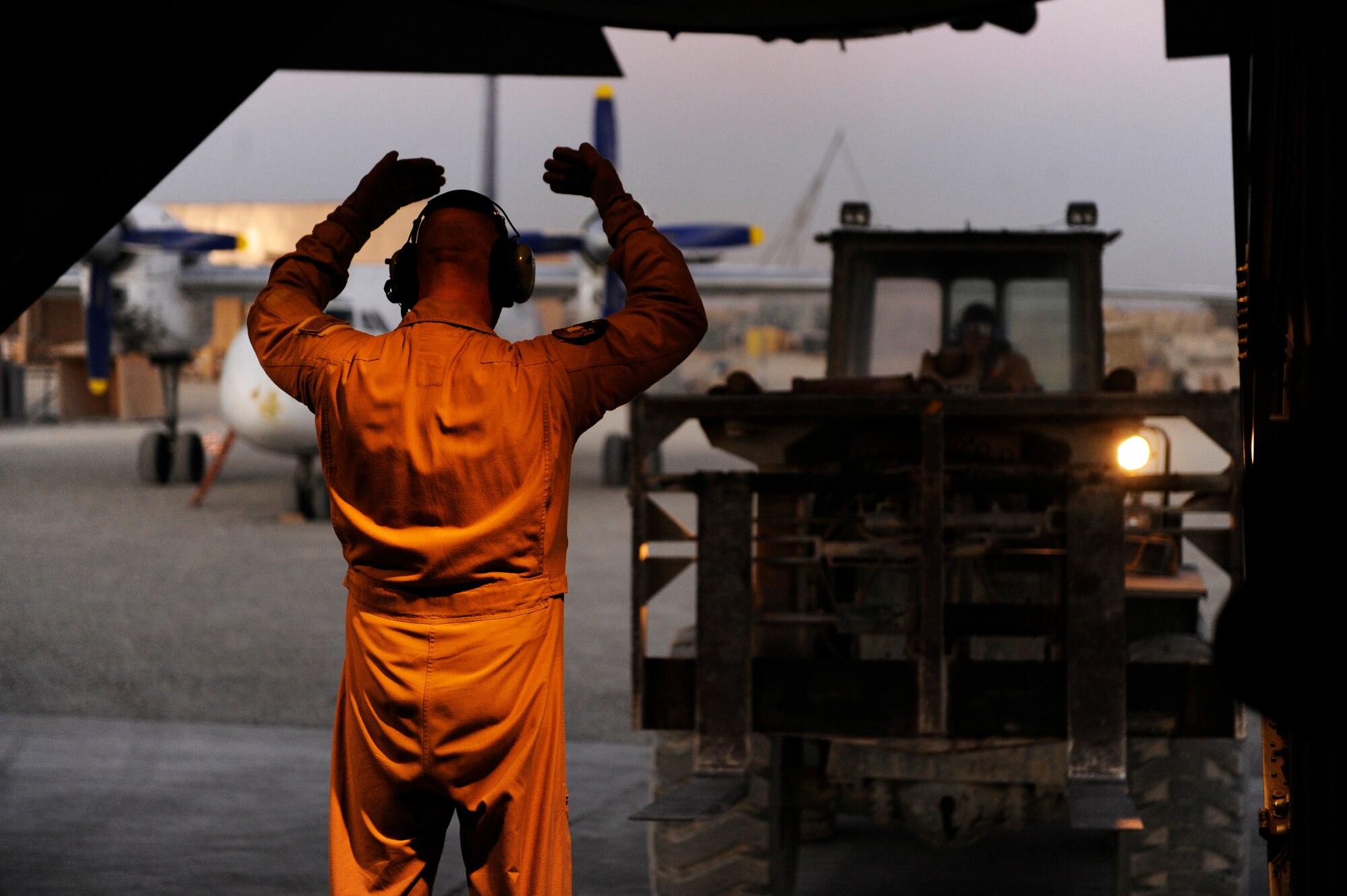 U.S. Air Force Master Sgt. Mike Saskowski, 774th Expeditionary Airlift Squadron, guides a forklift towards a C-130H Hercules in order to unload pallets during a transport mission in support of Operation Enduring Freedom at Forward Operating Base Sharana, Afghanistan, Jan 4, 2011.  C-130s are able to land on runways that many other cargo aircraft are unable to, making them invaluable when moving passengers and cargo.  (U.S. Air Force Photo/Staff Sgt. Eric Harris) (RELEASED)