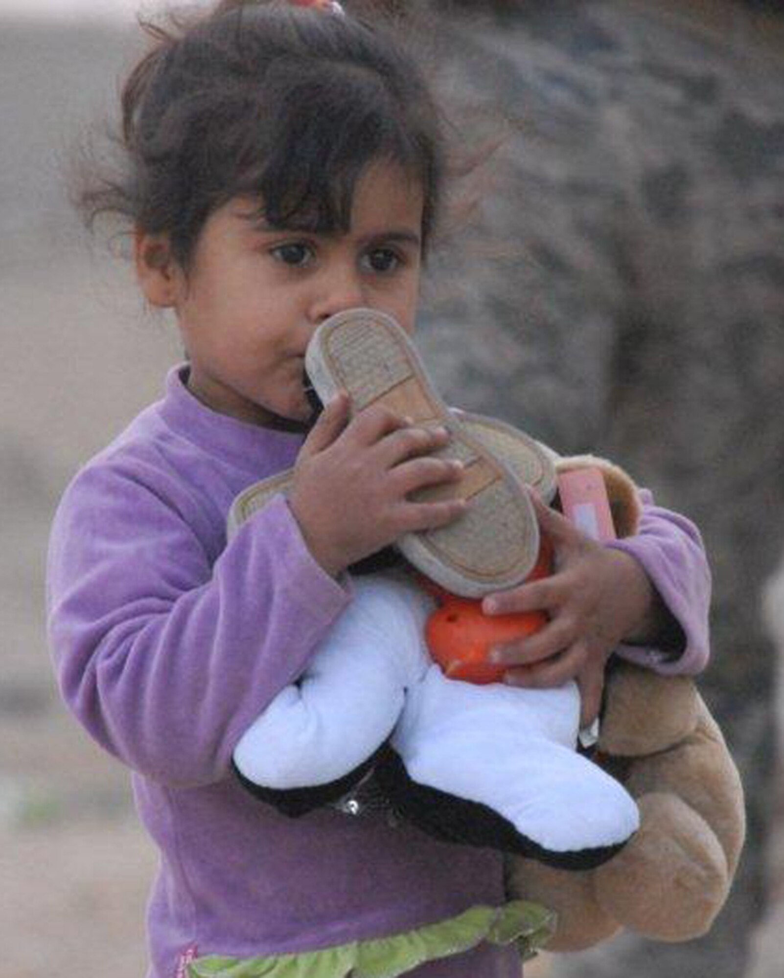 A young Iraqi girl hugs the toys and shoes she received from the Echelon Above Division-Advise and Train team Dec. 16 at Ur Elementary School near Tallil Air Base, Iraq. Airmen assigned to the EAD-AT team handed out school supplies and toys to more than 70 children. (U.S. Army photo by Spc. Chastity Boykin)