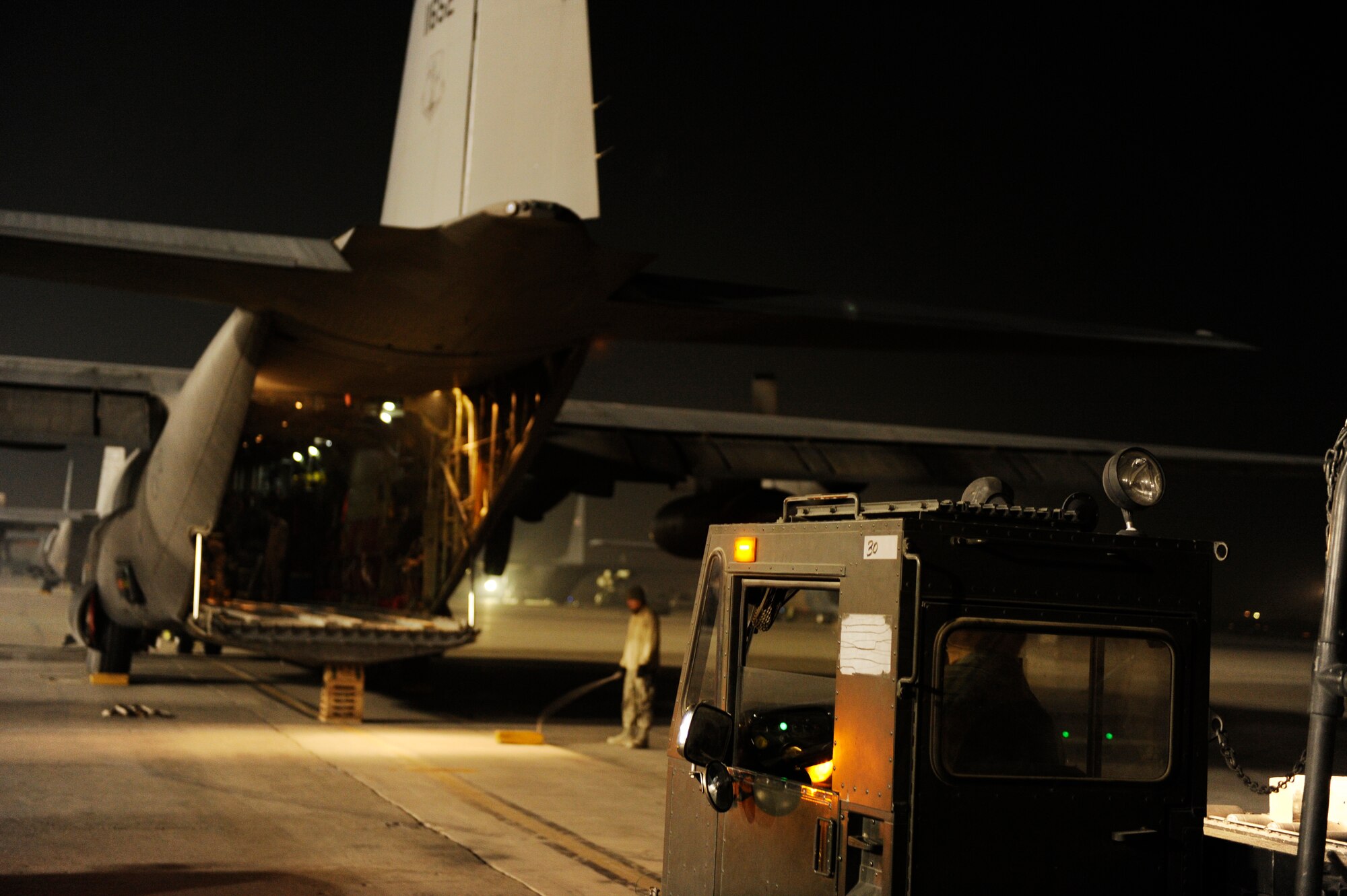 A U.S. Air Force K-loader waits to load pallets aboard a C-130H Hercules from the 774th Expeditionary Airlift Squadron at Bagram Airfield, Afghanistan before a mission to deliver supplies to forward operating bases in support of Operation Enduring Freedom, Jan 2, 2011.  C-130 aircrews deliver supplies by air to reduce the number of ground convoys that are at risk.  (U.S. Air Force Photo/Staff Sgt. Eric Harris) (RELEASED)
