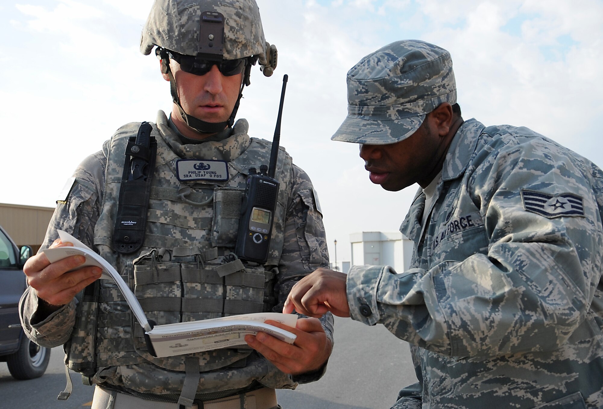 Staff Sgt. Vincent Sims, post-attack recon team member, identifies the unexploded ordinance that was found during an exercise to Senior Airman Philip Young, an explosive ordnance disposal team member, Jan. 6. Sergeant Sims is with the 386th Expeditionary Force Support Squadron and Airman Young is with the 386th Expeditionary Civil Engineer Squadron. (U.S. Air Force photo by Senior Airman Cynthia Spalding) 