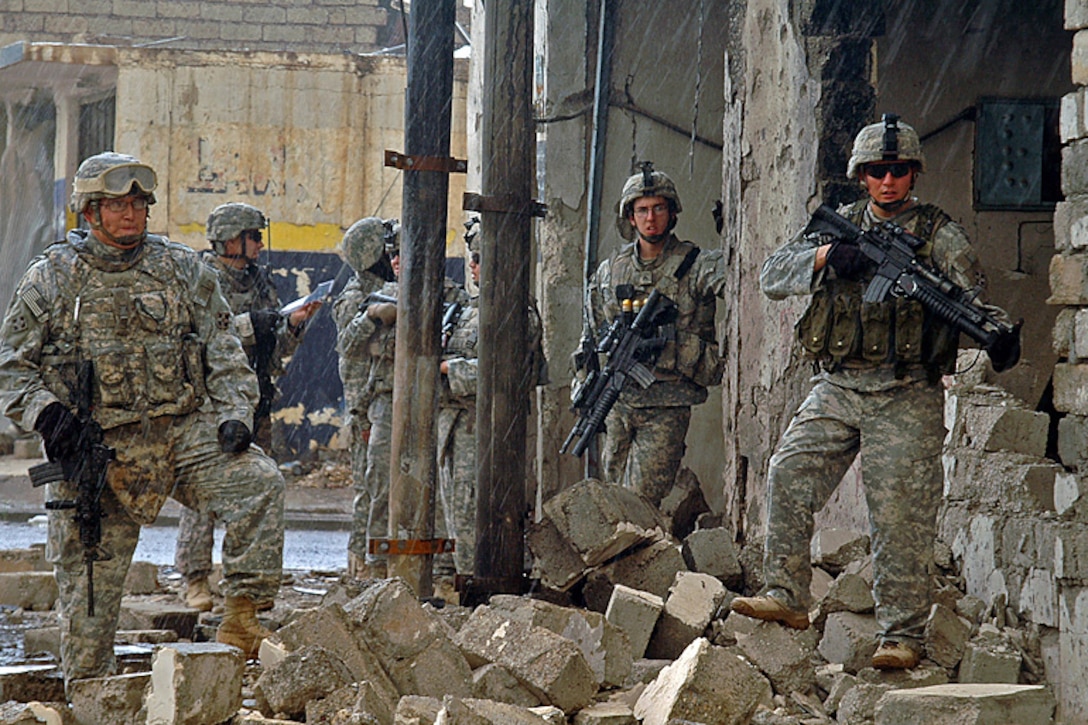 Soldiers patrol through the rubble-laden streets of al-Sinaa neighborhood in Mosul, Iraq, April 1, 2008. These soldiers from Company D, 1st Battalion, 8th Infantry Regiment, 4th Infantry Division, raided the neighborhood, found and cleared a bomb factory and weapons cache.