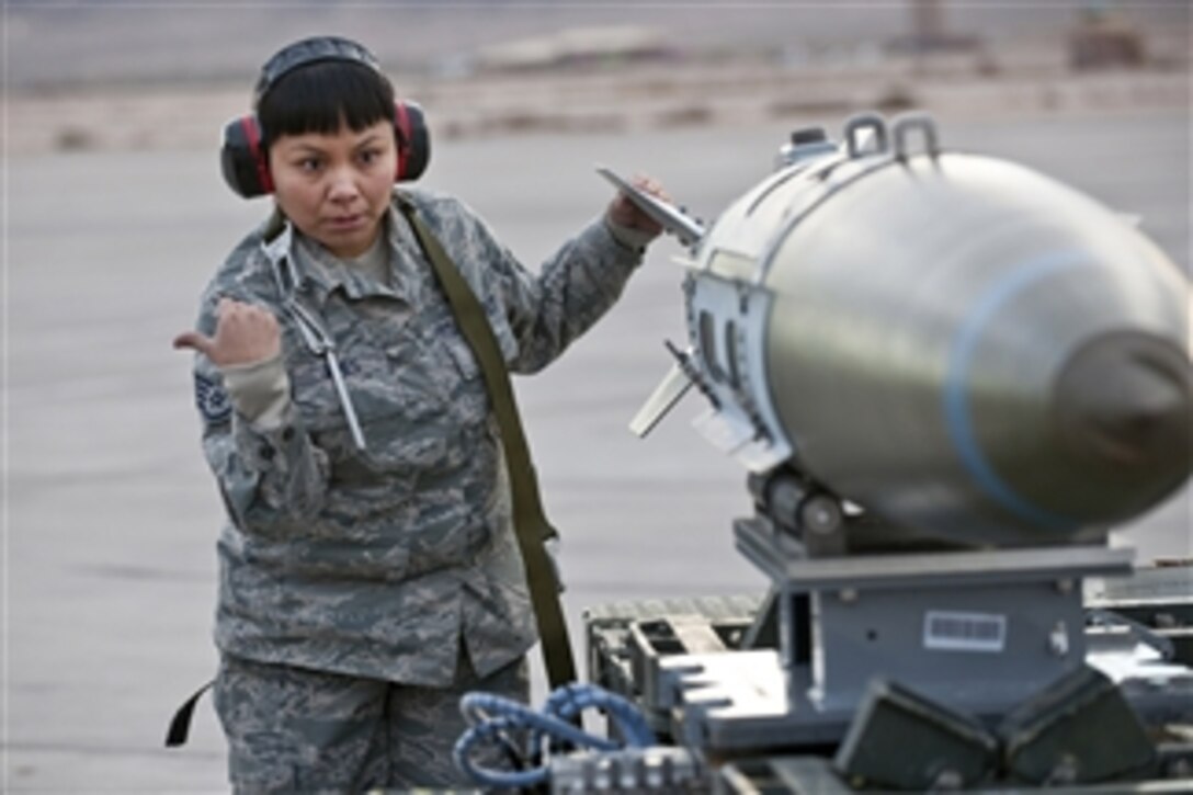 U.S. Air Force Staff Sgt. Ragina James, an aircraft armament systems craftsman with the 57th Aircraft Maintenance Squadron, directs a driver while they move a MK-84 bomb to a trailer during a weapons load competition at Nellis Air Force Base, Nev., on Jan. 7, 2011.  