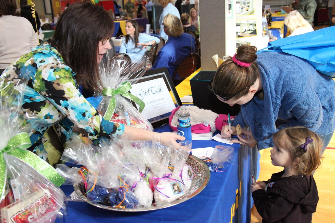 Dr. Jennifer W. Orr, left, keeps 2-year-old, Kaiya Hirschfield busy while her mom, Trina N. Hirschfield, fills out a form at Orr’s booth during the 2011 MCAS Cherry Point Health Fair at the Cherry Tree House Jan. 13. Orr, a physician at a local medical facility in Morehead City, said the fair was a great way to show the health options available outside the air station.