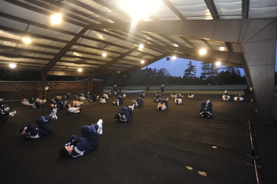 Airmen perform callisthenic exercises as part of the newly implemented "PT Boot Camp" on Jan. 12, 2010, at Joint Base Lewis-McChord, Wash. If an Airman scores 74.99 or below on the PT test, they are required to attend the new fitness program. PT Boot Camp consists of a one-hour training session, five days a week, to include one non-duty day. (U.S. Air Force Photo/Airman Leah Young) 
