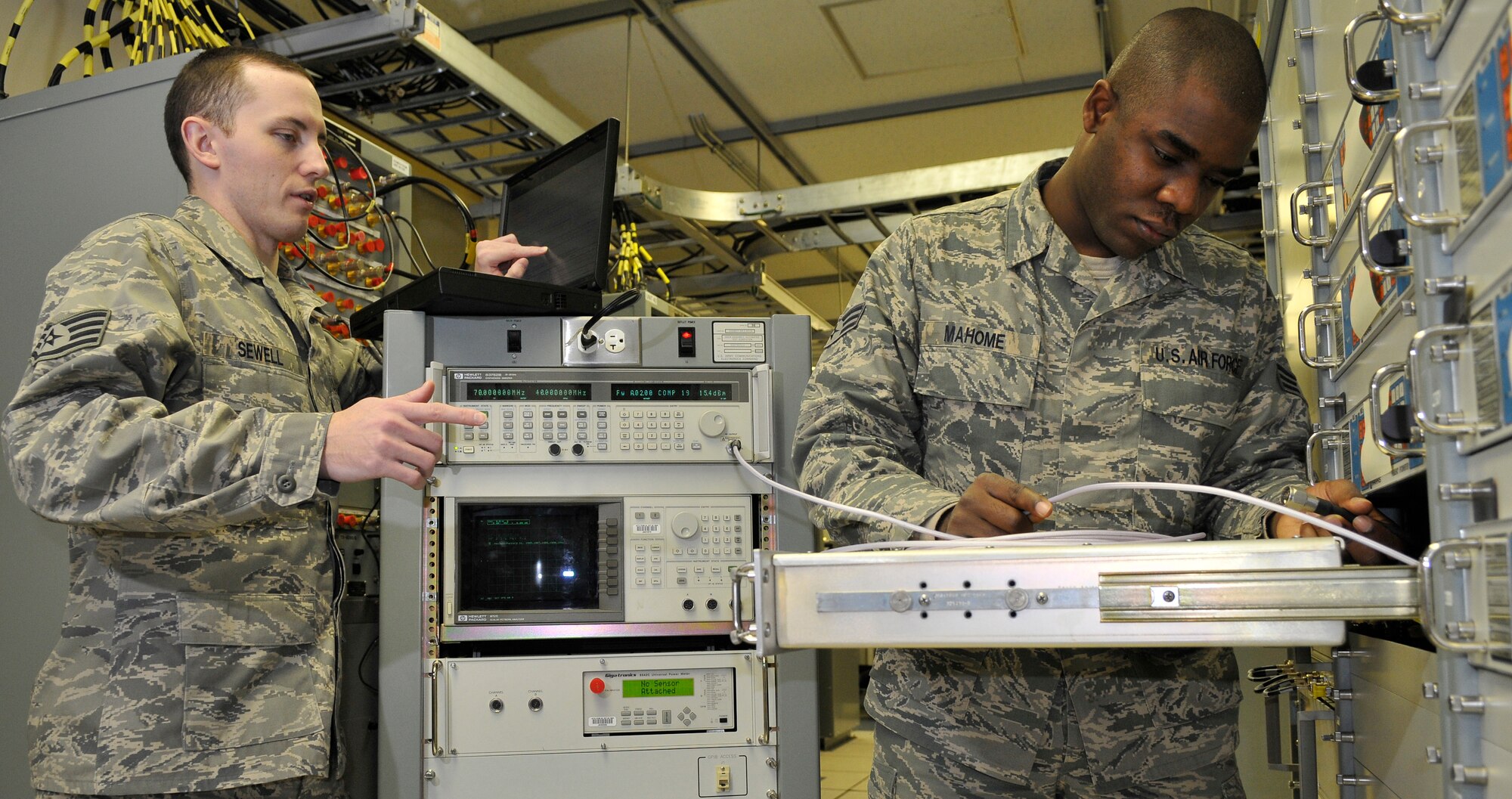 U.S. Air Force Staff Sgt. Randy Sewell and Senior Airman Bobby Mahome, 35th Communication Squadron radio frequency transmissions systems technicians, connect test equipment to a radio frequency signal up-converter Jan. 11, 2011, Misawa Air Base, Japan. Up-converters are used to boost signal strength before going to the satellite antenna for transmission. (U.S. Air Force photo by Tech. Sgt. Phillip Butterfield/Released)    