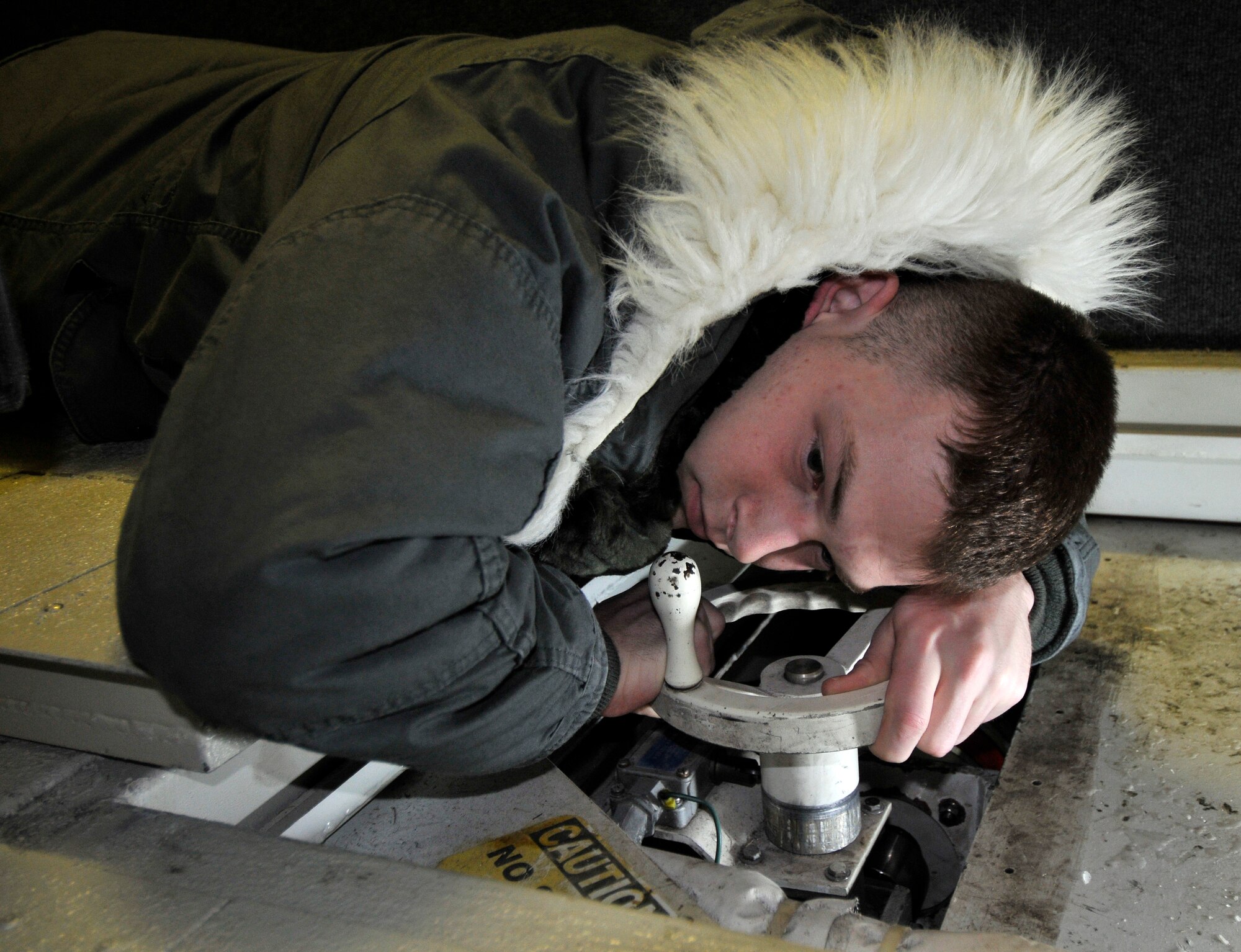 U.S. Air Force Senior Airman Randell Rountree, 35th Communication Squadron radio frequency transmissions systems technician, listens for sounds of wear on gears in a satellite antenna gear box Jan. 11, 2011, Misawa Air Base, Japan. When gears start to wear out, they emit an audible clicking, grinding sound as they slip past other gears in the box. RFTS technicians perform preventative maintenance and inspections on equipment to ensure proper operation. (U.S. Air Force photo by Tech. Sgt. Phillip Butterfield/Released)    