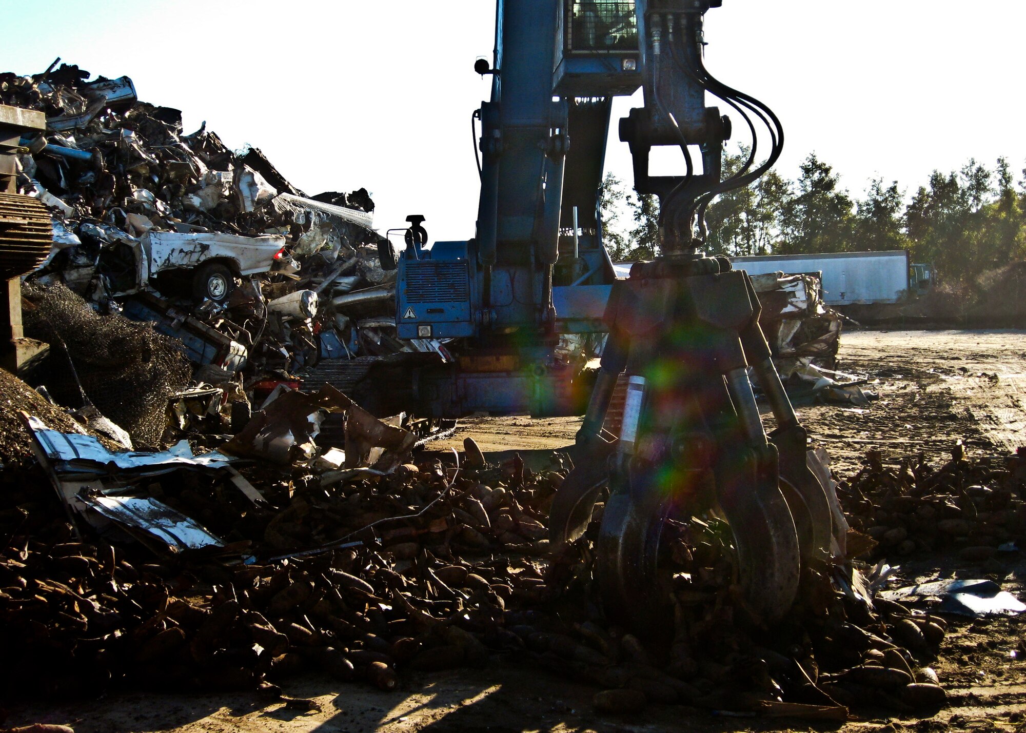 A large mechanical claw at a commercial shredding facility near Eglin Air Force Base, Fla., grabs a load of discarded miniature practice bombs that will be fed into a shredder.  The shredded material then will be recycled.  To date, more than seven million pounds of range debris metal have been recycled, saving the government millions of dollars. (Courtesy photo)