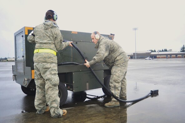Staff Sgt. Amaya Talley, left, and Airman 1st Class Brad Harrel, both 62nd Aircraft Maintenance Squadron silver aircraft maintenance unit crew chiefs, wrap up a power cord on a generator Jan. 13, 2010, at Joint Base Lewis-McChord, Wash. (U.S. Air Force Photo/Airman Leah Young) 