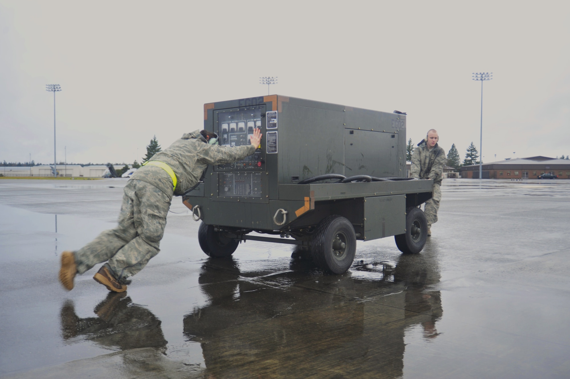 Staff Sgt. Amaya Talley, left, and Airman 1st Class Brad Harrel, both 62nd Aircraft Maintenance Squadron silver AMU crew chiefs, move a generator away from an aircraft Jan. 13 at Joint Base Lewis-McChord, Wash. The generator must be a certain distance away from an aircraft before it takes off. (U.S. Air Force photo/Airman Leah Young)