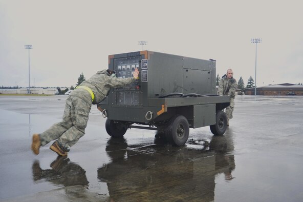 Staff Sgt. Amaya Talley, left, and Airman 1st Class Brad Harrel, both 62nd Aircraft Maintenance Squadron silver AMU crew chiefs, move a generator away from an aircraft Jan. 13, 2010, at Joint Base Lewis-McChord, Wash. The generator must be a certain distance away from an aircraft before it takes off. (U.S. Air Force Photo/Airman Leah Young) 
