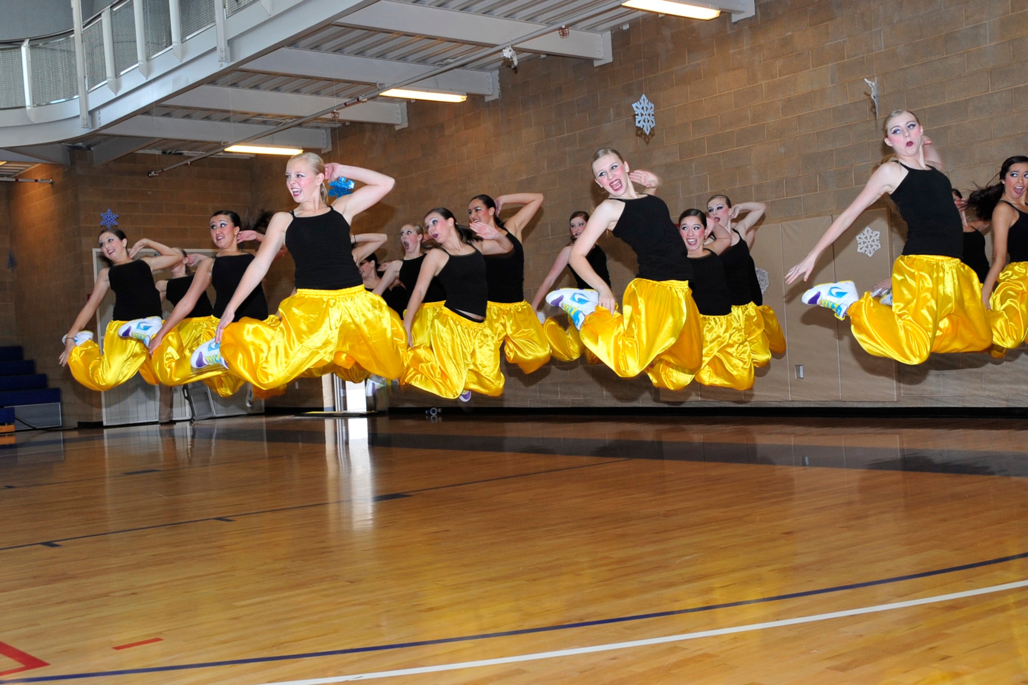 The Layton High Lancelles dance group jumps in unison during a performance at the Winter Travel and Wellness Expo on Nov. 17 at the Warrior Health and Fitness Center. A host of wellness organizations, travel services and others sent representatives to answer questions and dispense information on a broad range of winter activities in Utah. ( U.S Air Force photo by Kim Cook)