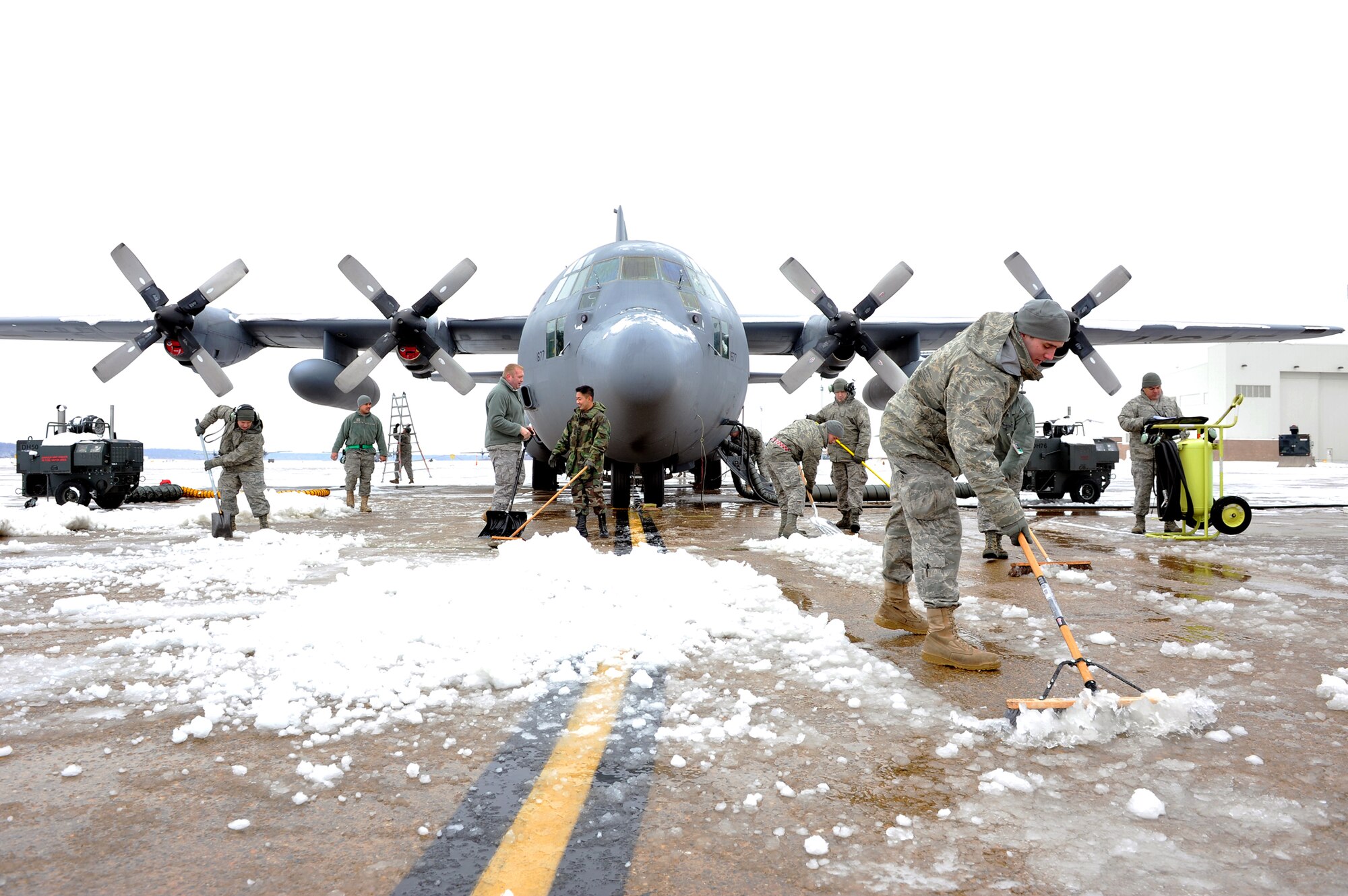 Members of the 19th Aircraft Maintenance Squadron shovel snow and ice away from a C-130 Hercules Jan. 10, 2011, on the flightline at Little Rock Air Force Base, Ark. This day brought in the first snow of the new year at Little Rock AFB. (U.S. Air Force photo/Staff Sgt. Chris Willis)