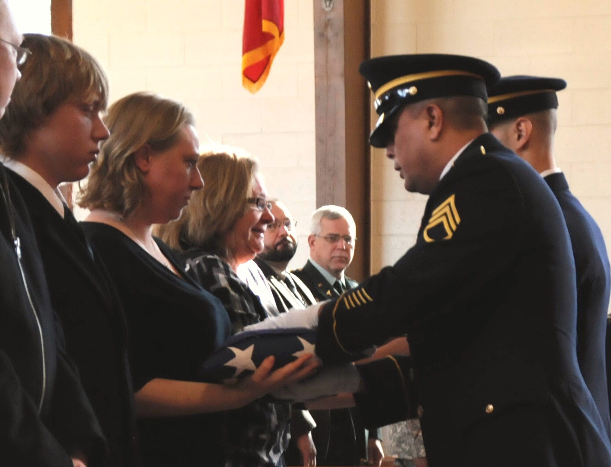 Joann Gregg and her daughter Heather receive Sgt. 1st Class Gregg’s remains and the American flag while sons Justin and Brian look on. (U.S. Air Force photo/ James Hodges)