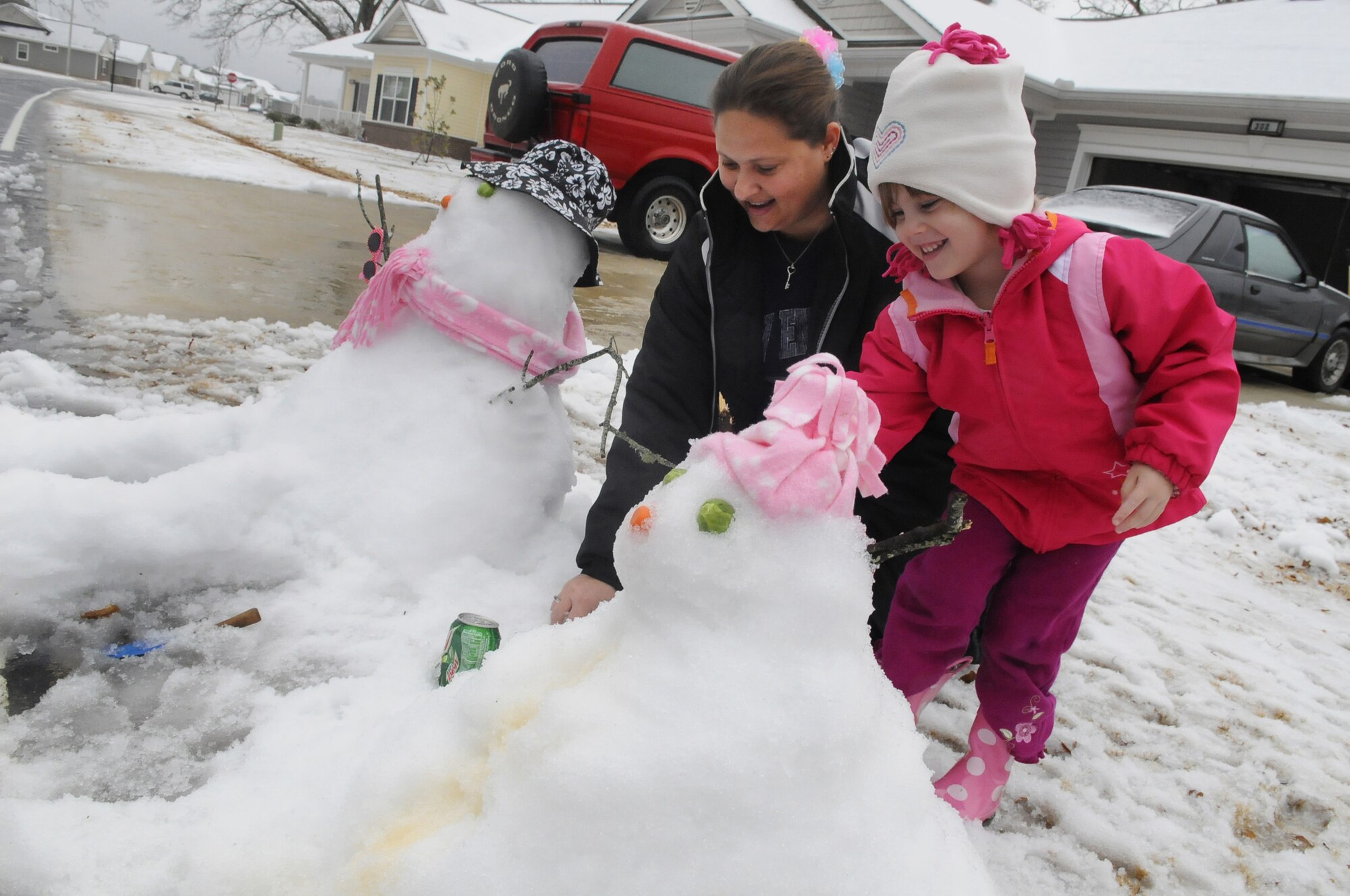 Rasberry and Jessica Surles, wife and daughter of Marine Gunnery Sgt. Brad Surles, work on a snowman and snowdog Monday at their home on Robins. In addition to children having the day off from school due to the inclement weather, non-mission essential base personnel were told not to report to work. U. S. Air Force photo by Sue Sapp