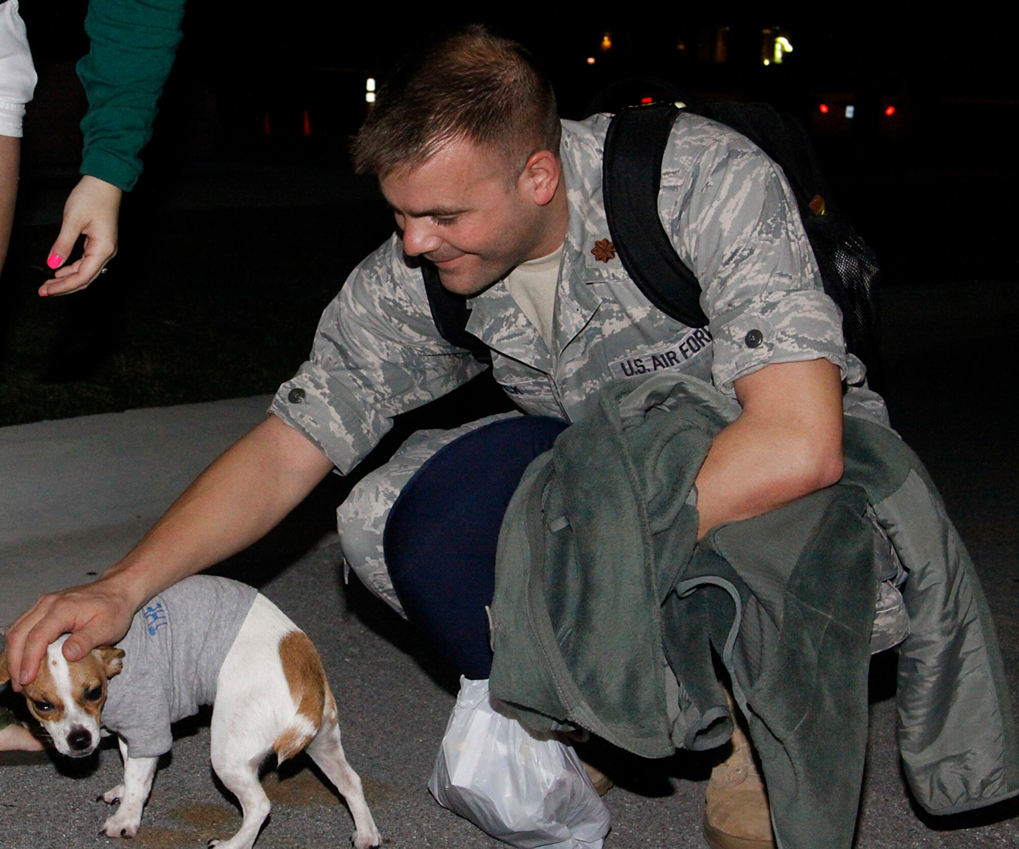 Maj. David Black, 482nd Aircraft Maintenance Squadron pets his dog “Bandit” Jan. 12 upon return from a training deployment in South Korea. Black was deployed for over 70 days. (U.S. Air Force photo/Airman 1st Class Jacob Jimenez)