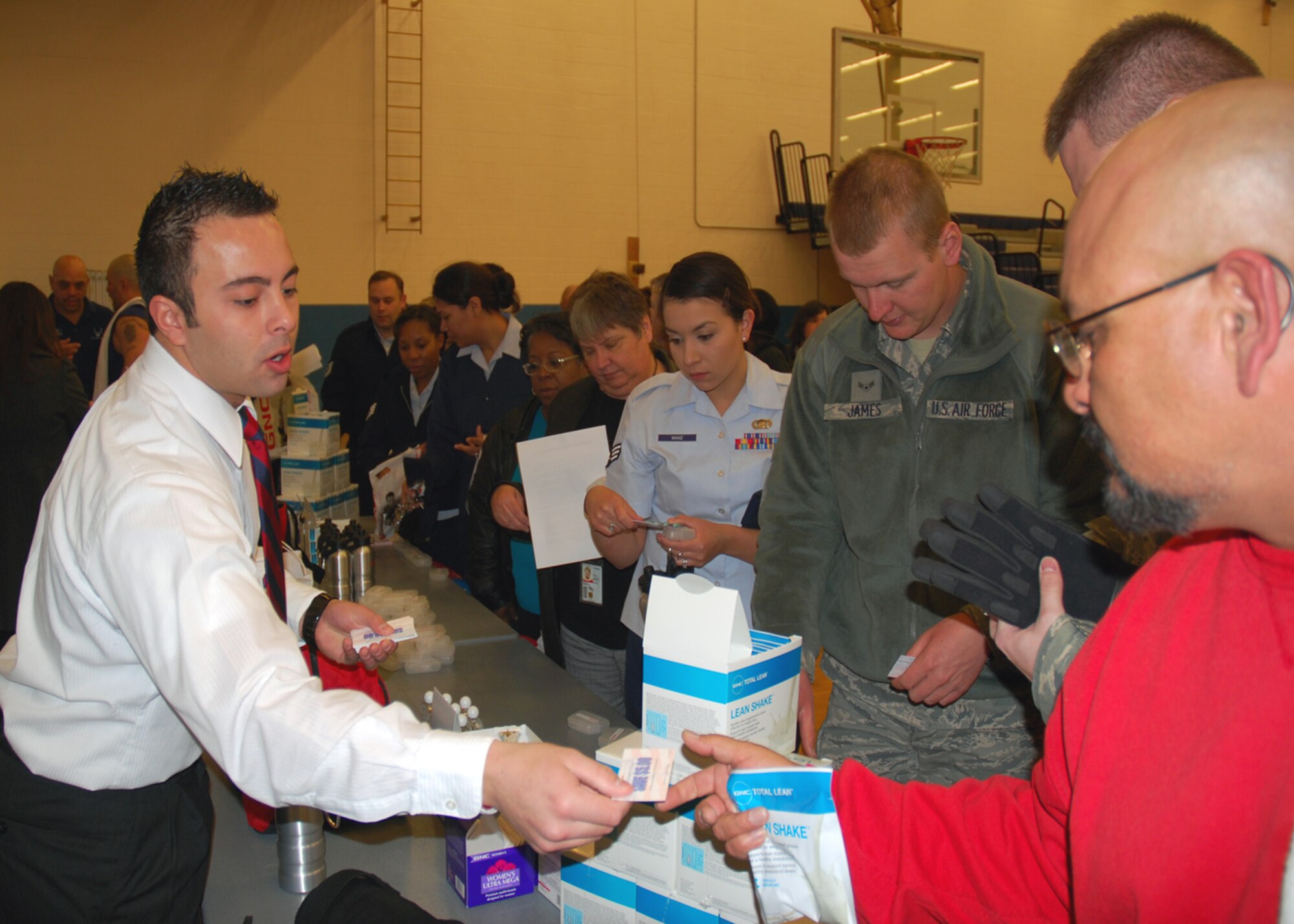 Justin Garrison, manager of the Clovis GNC store, offers coupons and product samples to participants at the Cannon's Biggest Loser kickoff Jan. 10 at the base fitness center.  GNC sponsors the competition, in which teams of four compete in a six-week program for total weight loss.  Prizes will be awarded to teams that lose the most weight between Jan. 10 and Feb. 18. (U.S. Air Force photo by 2nd Lt. Stephanie Strine)