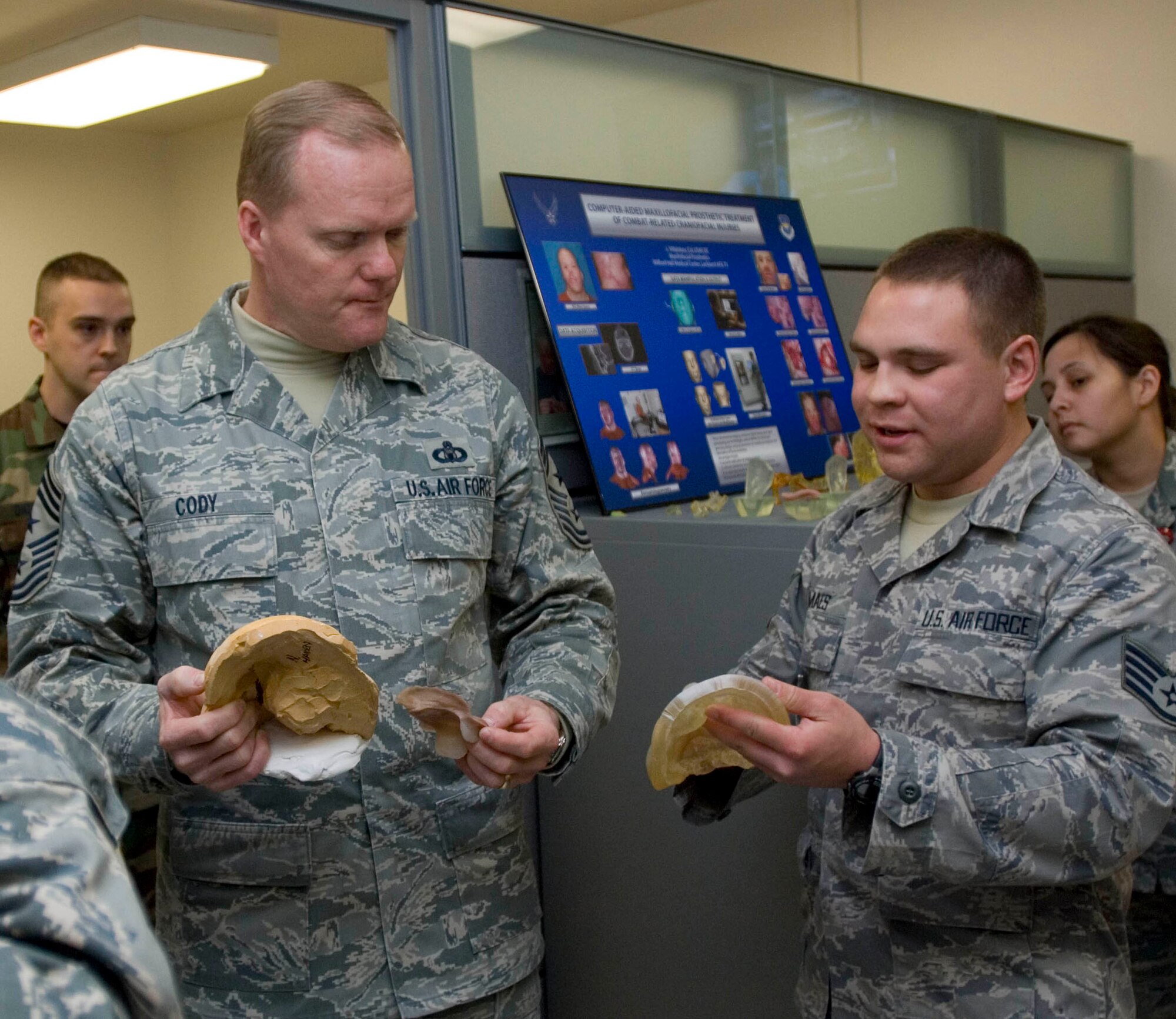 Staff Sgt. Christian Maes, 59th Dental Squadron dental laboratory journeyman (right), shows Chief Master Sgt. James Cody, Air Education and Training Command Chief (center), models he helped create using sterolithography at the MacKown Dental Clinic, Lackland Air Force Base, Texas, Jan. 12. The stereolithography lab on Lackland is one of only a few in the Department of Defense that creates prosthetic body parts, such as eyes, ears, and noses for wounded warriors. (U.S. Air Force photo/Senior Airman Corey Hook)
























 