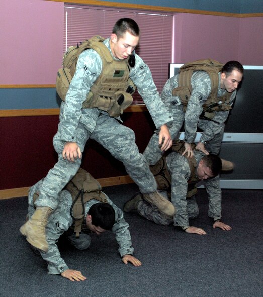 Airman 1st Class Steven Greer, a 341st Security Forces Group Tactical Response Force member, partners with fellow TRF member Airman 1st Class Aaron Simpson (left) while Senior Airman Maxwell Thompson, 341st SFG/TRF member, partners with Tech. Sgt. Kevin Akers, 341st SFG/TRF 912th flight chief, in a leap frog exercise.  Sergeant Akers leads his team in PT by participating in every exercise. (U.S. Air Force photo/Airman Cortney Hansen)