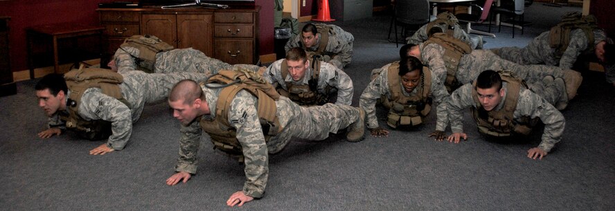 Members of the 341st Security Forces Group Tactical Response Force perform pushups with their gear on.  Weighing roughly 20 pounds, their vests are used as an accessory when PT-ing. (U.S. Air Force photo/Airman Cortney Hansen)