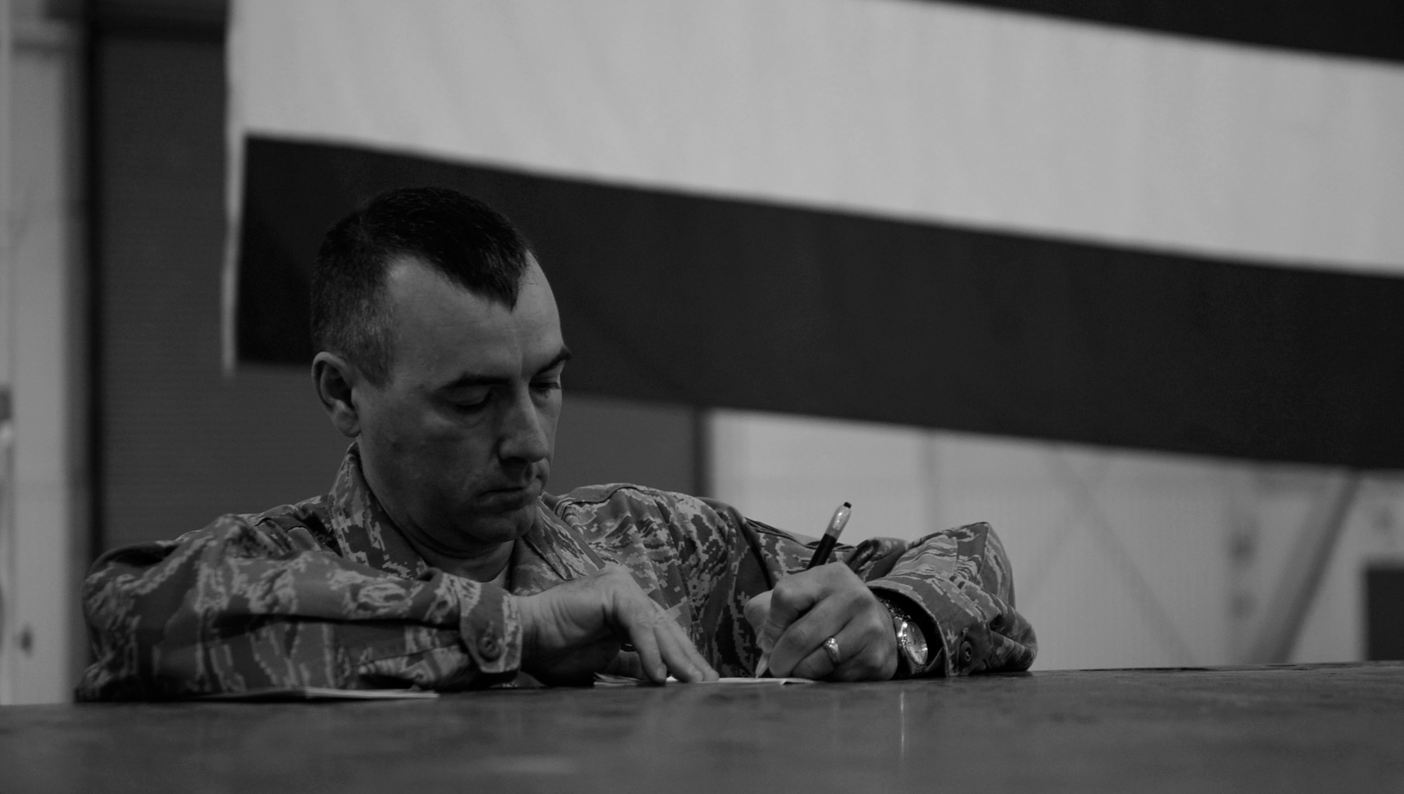 MOUNTAIN HOME AIR FORCE BASE, Idaho -- Chief Master Sgt. Ronald McCarthy, 366th Fighter Wing command chief, writes down notes before speaking at a commander’s call Jan. 7 at Hangar 1331. The commander’s call covered many topics varying from suicide awareness, DUIs, and the upcoming unit compliance inspection.  (U.S. Air Force photo by Senior Airman Renishia Richardson)