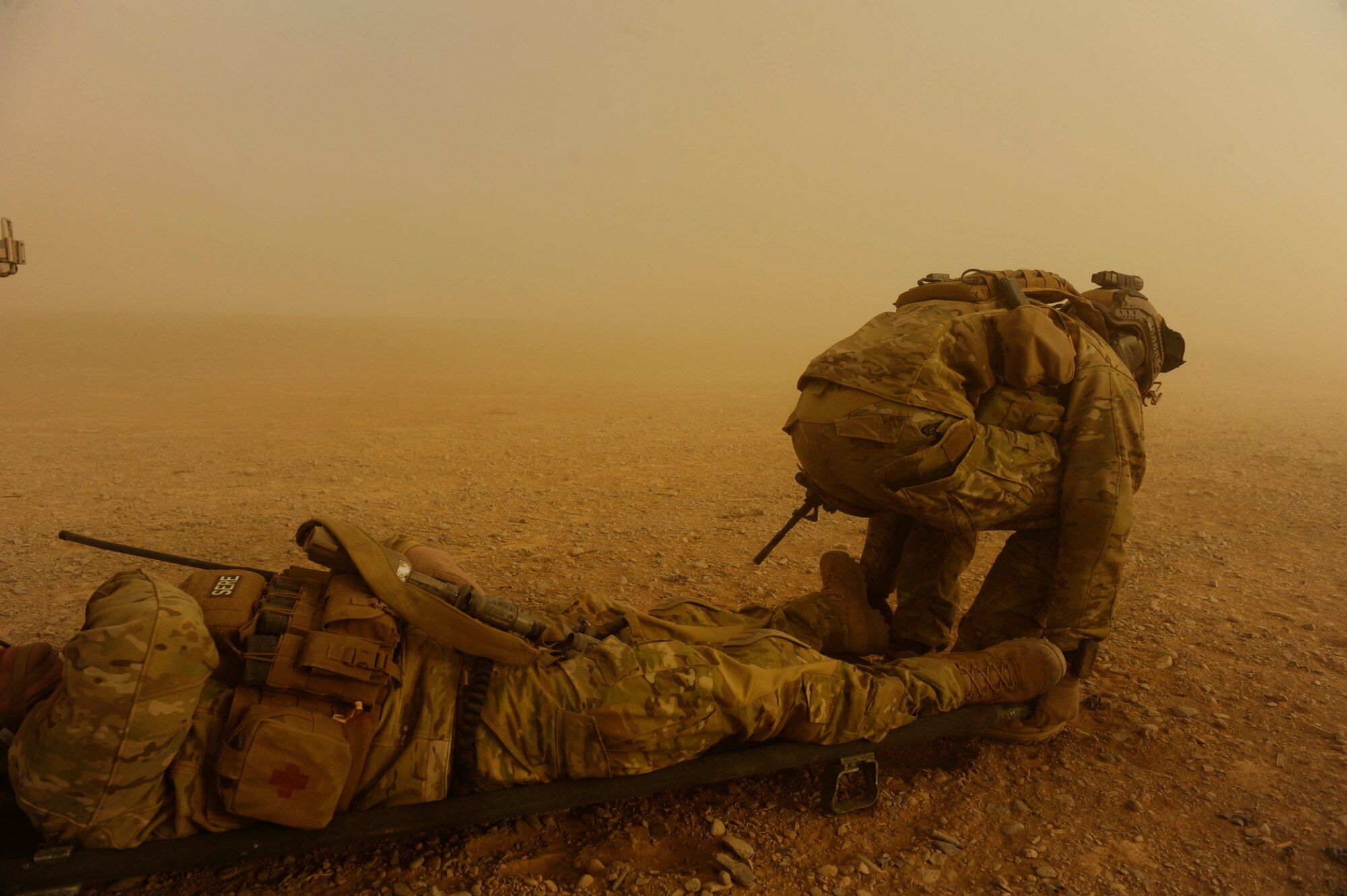 Captain Nick Morgans, 46th Expeditionary Rescue Squadron, and Tech. Sgt. Anthony Wood (not pictured) prepare to move a simulated casualty in order to load him onto an HH-60 Pave Hawk during a mass casualty scenario near Kandahar, Afghanistan, Dec. 24, 2010.  The scenario was planned as part of Sgt. Wood's qualification to become an element leader.  (U.S. Air Force Photo/Staff Sgt. Eric Harris) (RELEASED)