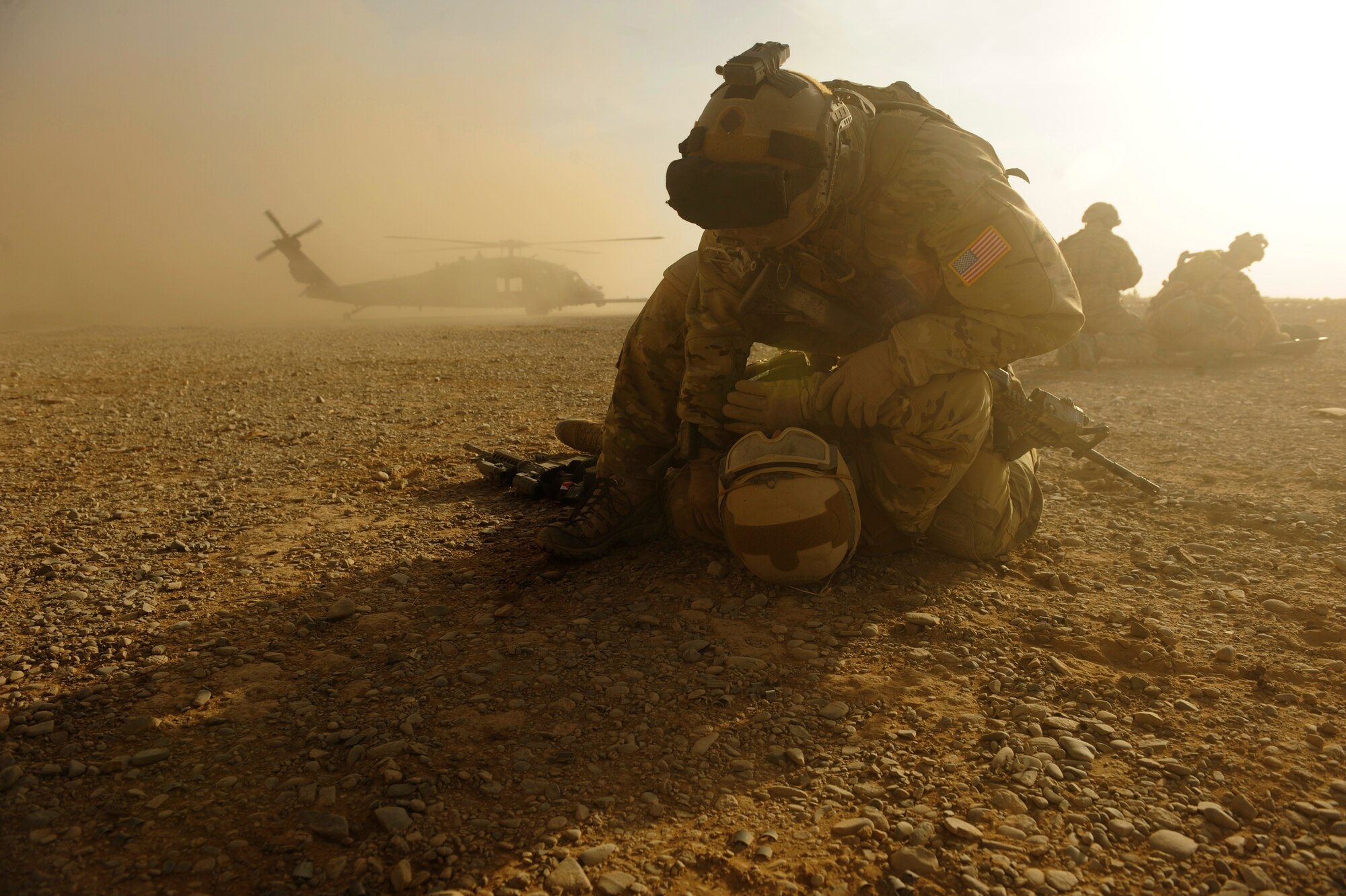 Captain Nick Morgans, 46th Expeditionary Rescue Squadron, covers a simulated casualty to protect him from flying dirt as an HH-60 Pave Hawk lands during a mass casualty scenario near Kandahar, Afghanistan, Dec. 24, 2010.  The scenario was planned as part of Tech. Sgt. Anthony Wood's qualification to become an element leader.  (U.S. Air Force Photo/Staff Sgt. Eric Harris) (RELEASED)