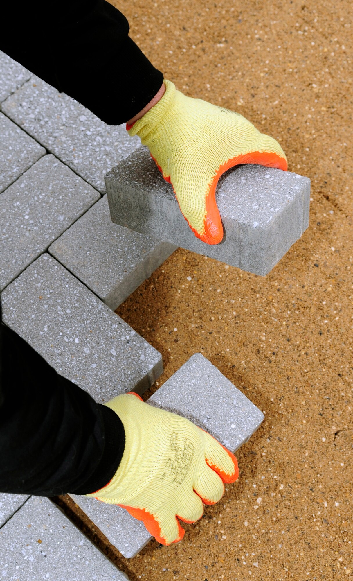 RAF MILDENHALL, England -- Bricks are used to block pave one of the paths being constructed throughout Washington Square Jan. 11, 2011. The base will save money by transforming the square into a green campus by reducing the maintenance costs of the failing pavement and drainage systems in the square. (U.S. Air Force photo/Senior Airman Ethan Morgan)