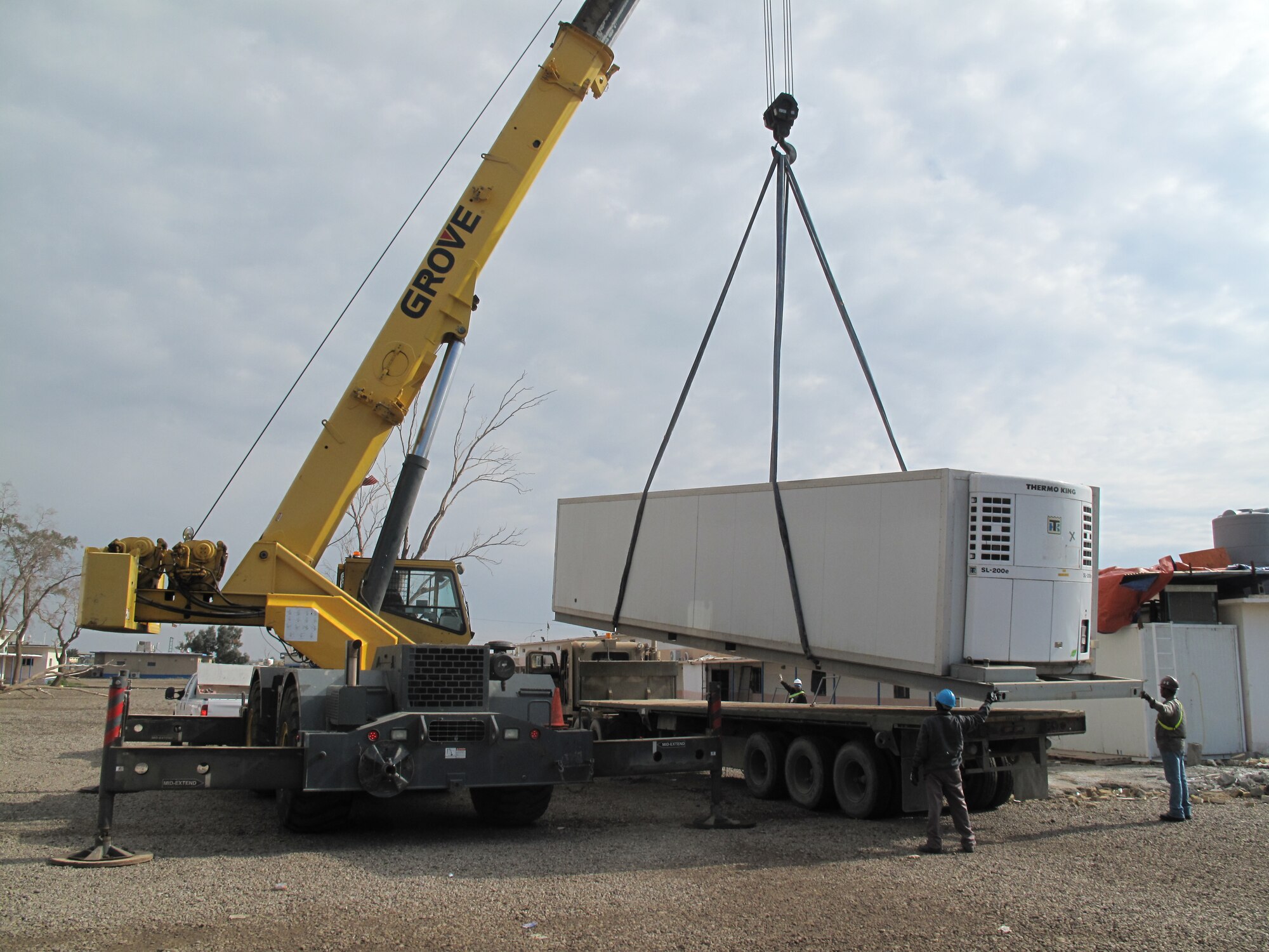 The Base Transition Team unloads a 40-foot, walk-in refrigerator unit for the new dining facility for the Iraqi Air Force Training School. The new facility is being constructed to handle the increasing number of students in attendance since the school re-opened in 2010.  (Courtesy photo)