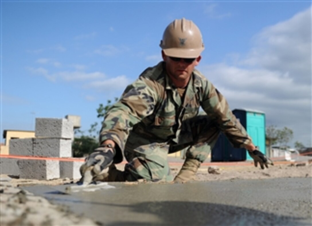 U.S. Navy Petty Officer 2nd Class Andras Toth, assigned to Naval Mobile Construction Battalion 28, trowels the foundation of a new classroom being built at the Jacobo Vera school in Manta, Ecuador, during Southern Partnership Station 2011 on Jan. 11, 2011.  Southern Partnership Station was a deployment of specialty platforms to the U.S. Southern Command area of responsibility in the Caribbean and Central America.  The mission's primary goal was information sharing with navies, coast guards and civilian services throughout the region.  