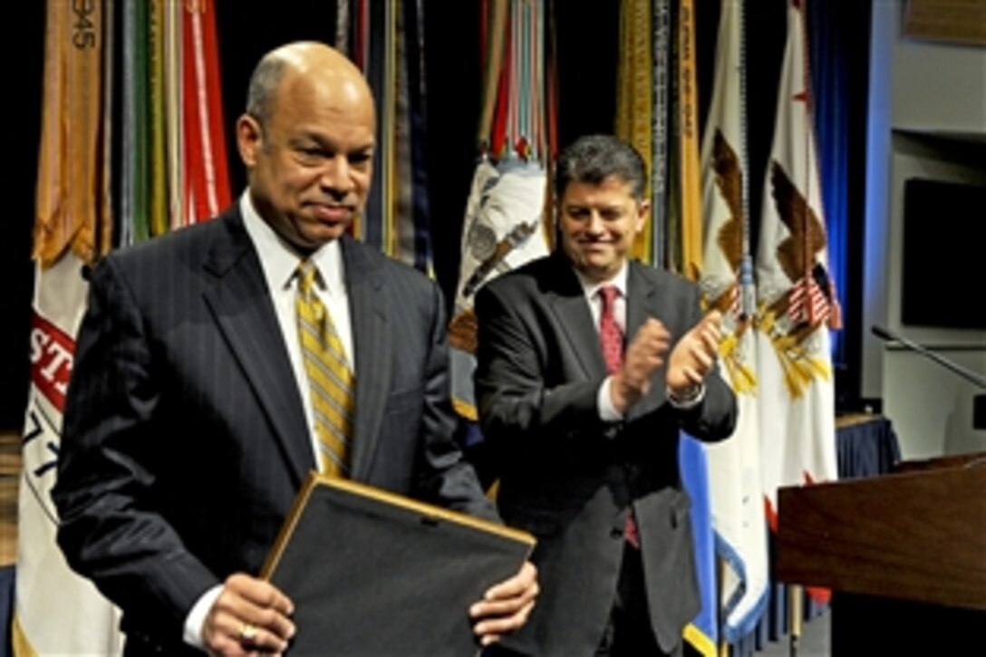 Michael L. Rhodes, the Defense Department's director of administration and management, applauds Jeh C. Johnson, the department's general counsel, after presenting him a certificate of appreciation for his keynote address at the 26th annual observance of the life of Dr. Martin Luther King Jr. at the Pentagon, Jan. 13, 2011.