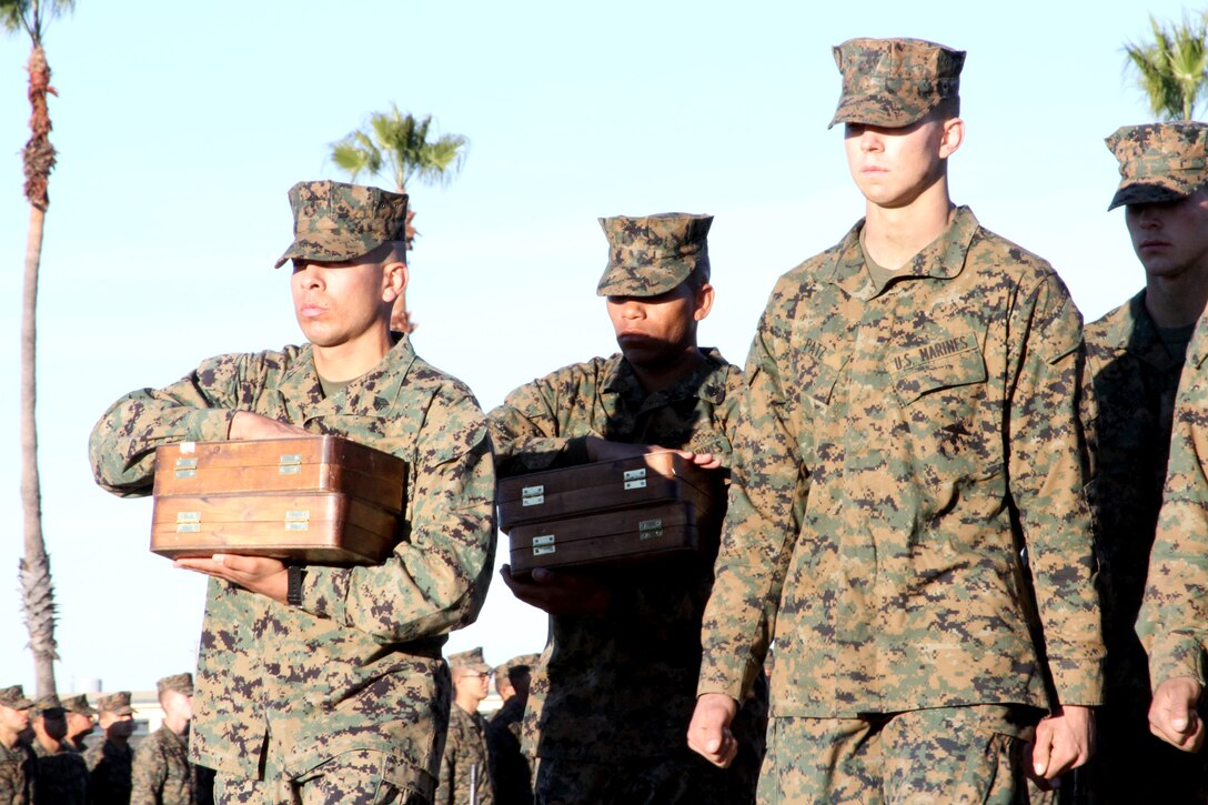 Drill instructors prepare to present eagle, globe, and anchor emblems to the nation’s newest Marines. The eagle, globe, and anchor ceremony is a formal presentation of the transition from recruit to Marine.