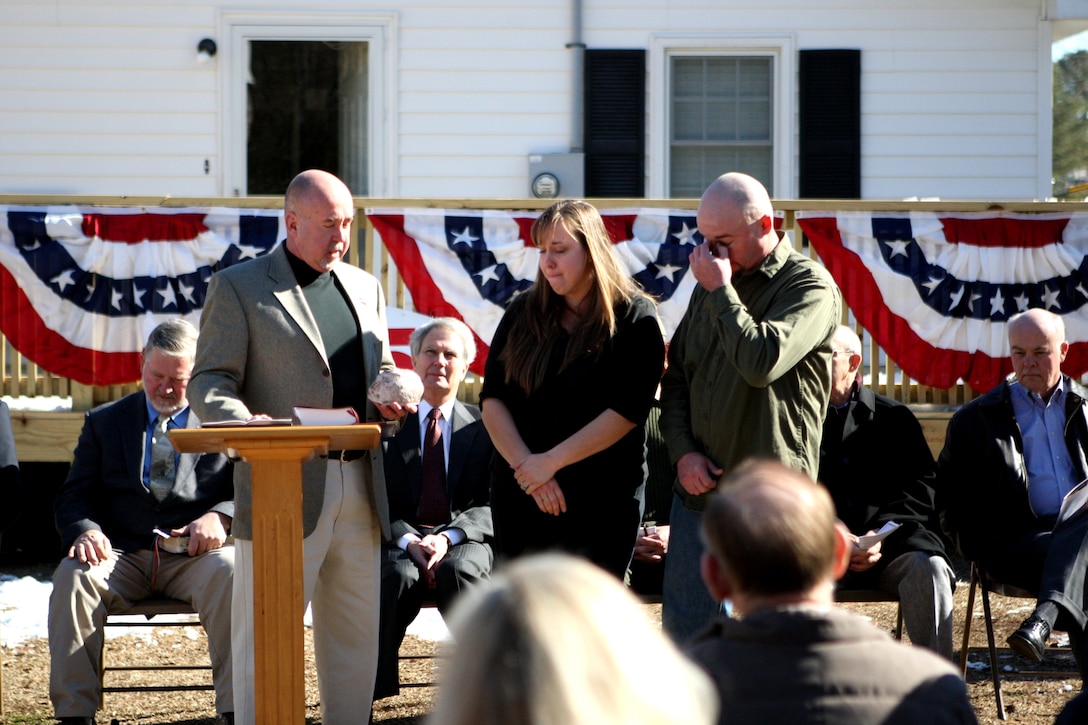 Warren Cottrell (right), a medically-retired sergeant with Post Traumatic Stress Disorder and Traumatic Brain Injury, and his wife Maria react to the words spoken by Mike Dorman, executive director of Military Missions in Action, during the dedication ceremony of their newly renovated house in Beulaville, N.C., Jan. 14. The Cottrells moved into their new house after a 30-day renovation by the Military Missions in Action organization and various volunteers from the community pitched in to remodel the house.