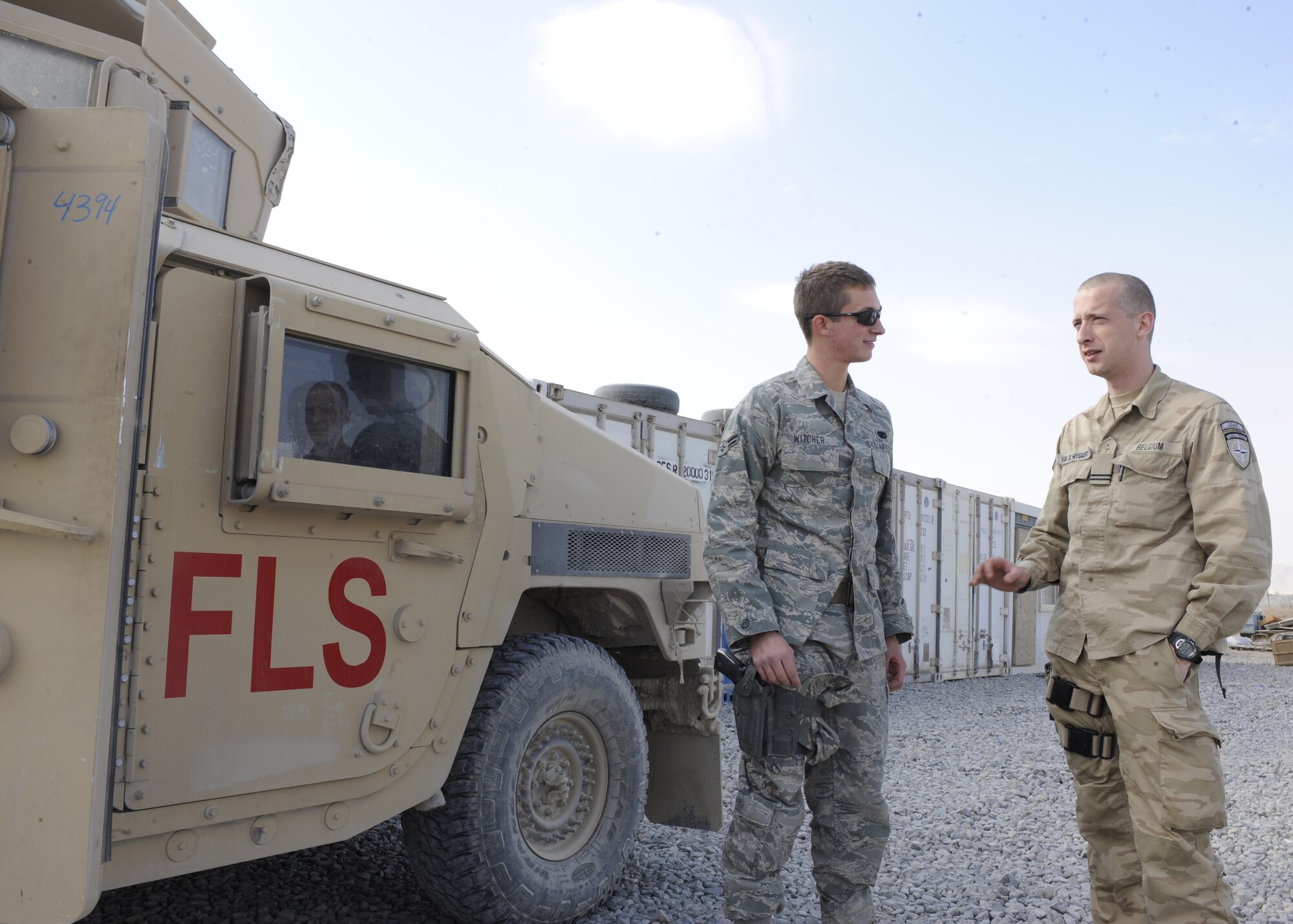 Airman 1st Class Shawn Witcher gives a situation report to Belgian Air Force Lt. Win van de Wygaert, Jan. 13, 2011, at Kandahar Air Field, Afghanistan. Airman Witcher is assigned to the 451st Expeditionary Security Forces Squadron working for Command of Kandahar Airfield Flightline Security. Lieutenant van de Wygaert is the COMKAF officer in charge of flightline security. (U.S. Air Force photo/Senior Airman Willard E. Grande II)