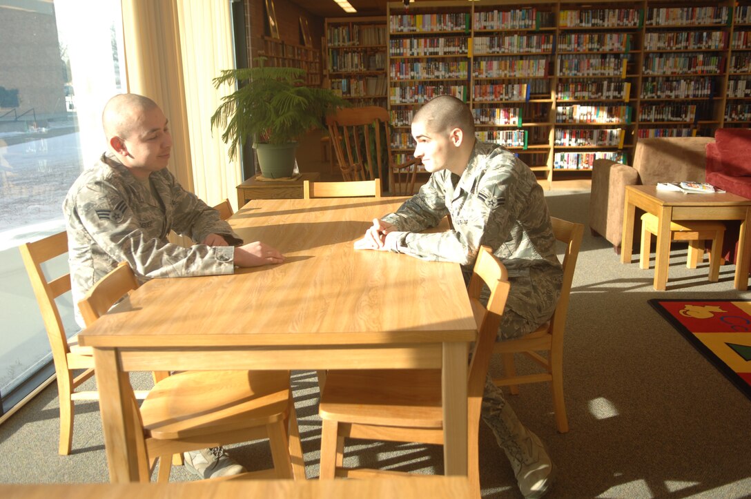 Senior Airman Casey Rodriguez, Air Force Financial Services Center temporary duty support finance technician, uses the second step of the Air Force suicide prevention ACE (Ask, Care and Escort) model by demonstrating the step focused on caring to listen to Airman 1st Class Terry Nartowicz, AFFSC reserve travel technician at Ellsworth Air Force Base, S.D., Jan. 12.  (U.S. Air Force photo/Airman 1st Class Alessandra N. Hurley)