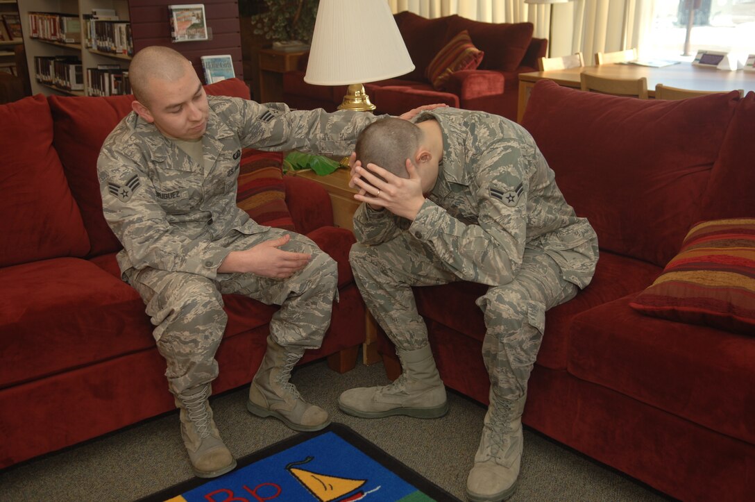 Senior Airman Casey Rodriguez, Air Force Financial Services Center temporary duty support finance technician, follows the first step of the Air Force suicide prevention ACE (Ask, Care and Escort) model by demonstrating the step focused on asking Airman 1st Class Terry Nartowicz, AFFSC reserve travel technician, how he is feeling at Ellsworth Air Force Base, S.D., Jan.
12.  The Air Force ACE model provides Airmen with a guide for being good wingmen by preventing suicide. (U.S. Air Force photo/Airman 1st Class Alessandra N. Hurley)
