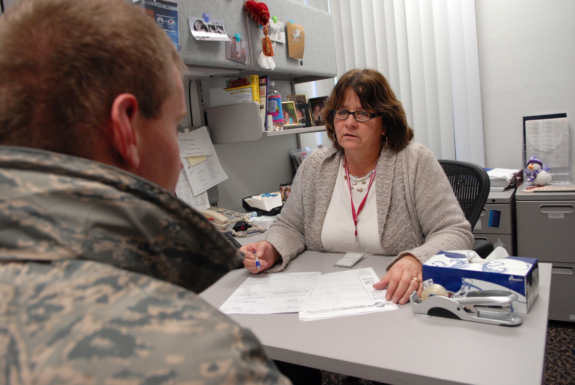 Annette Lupo discusses Tricare benefits with an airman in her office on Monday, January 10, 2011 at the 90th Medical Group base clinic here. Lupo, assigned to the Tricare Operations and Patient Administration office, was named the Global Strike Command Health Benefit Adviser of the Year. (U.S. Air Force photo by R.J. Oriez)
