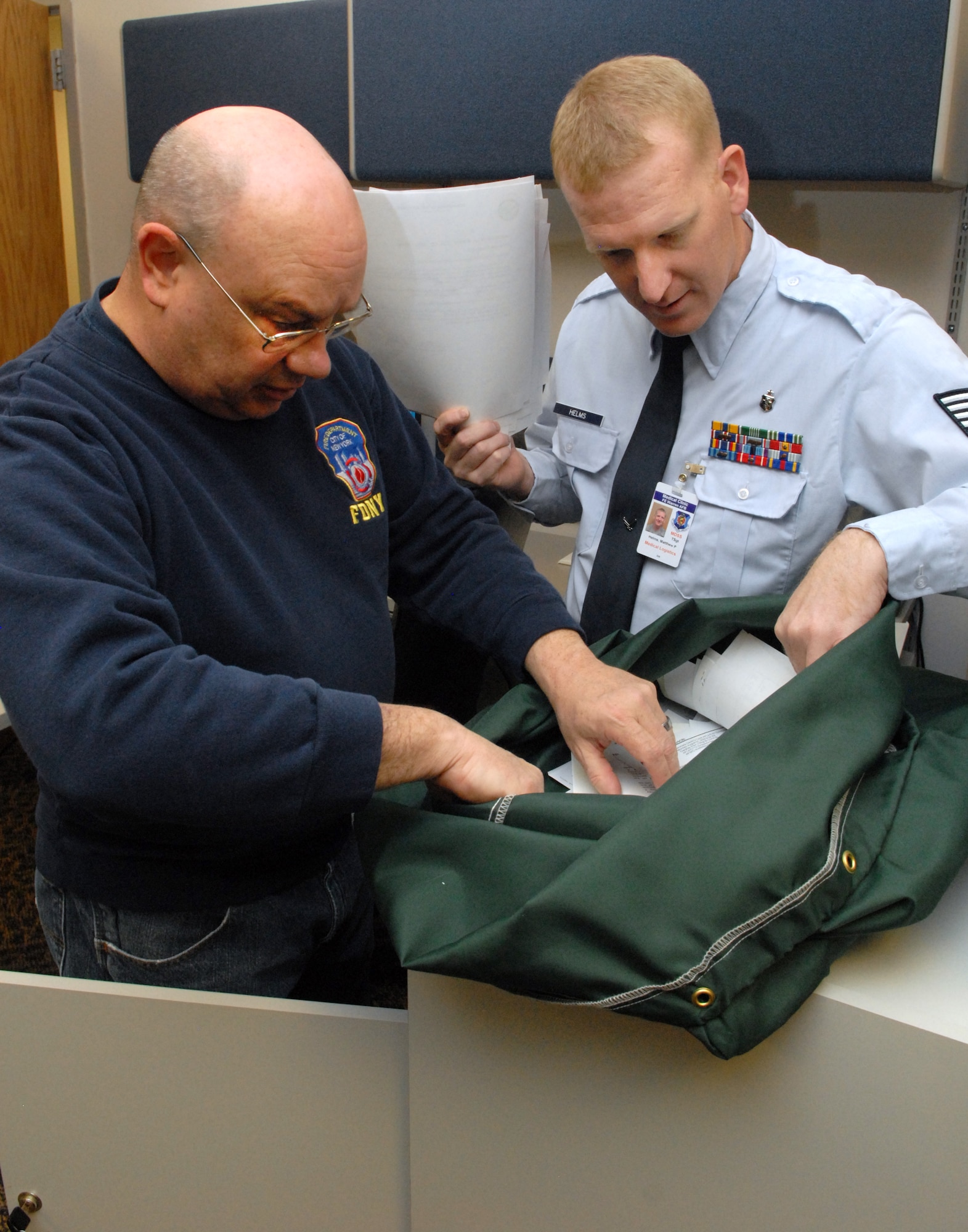 Tech. Sgt. Matthew Helms, helps Steve West, 90th Medical Group emergency manager, sort through documents pending termination or filing. Helms has been honored as the Global Strike Command's outstanding biomedical equipment repair noncommissioned officer of the year. (U.S. Air Force photo by R.J. Oriez)
