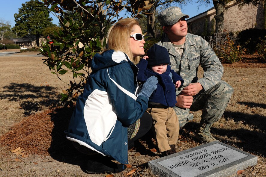 MOODY AIR FORCE BASE, Ga.-- Airman 1st Class Simon Martin, wife, Valerie, and their son, Grayson, pose in front of a tree dedicated to their deceased son, Karson Thomas Martin, Jan. 14. The 23rd Communications Squadron planted a magnolia tree and placed a stone monument  outside Building 109 in honor of Airman Martin’s son who passed away after a car crash in May 2010. (U.S. Air Force photo/Airman 1st Class Benjamin Wiseman)(RELEASED)