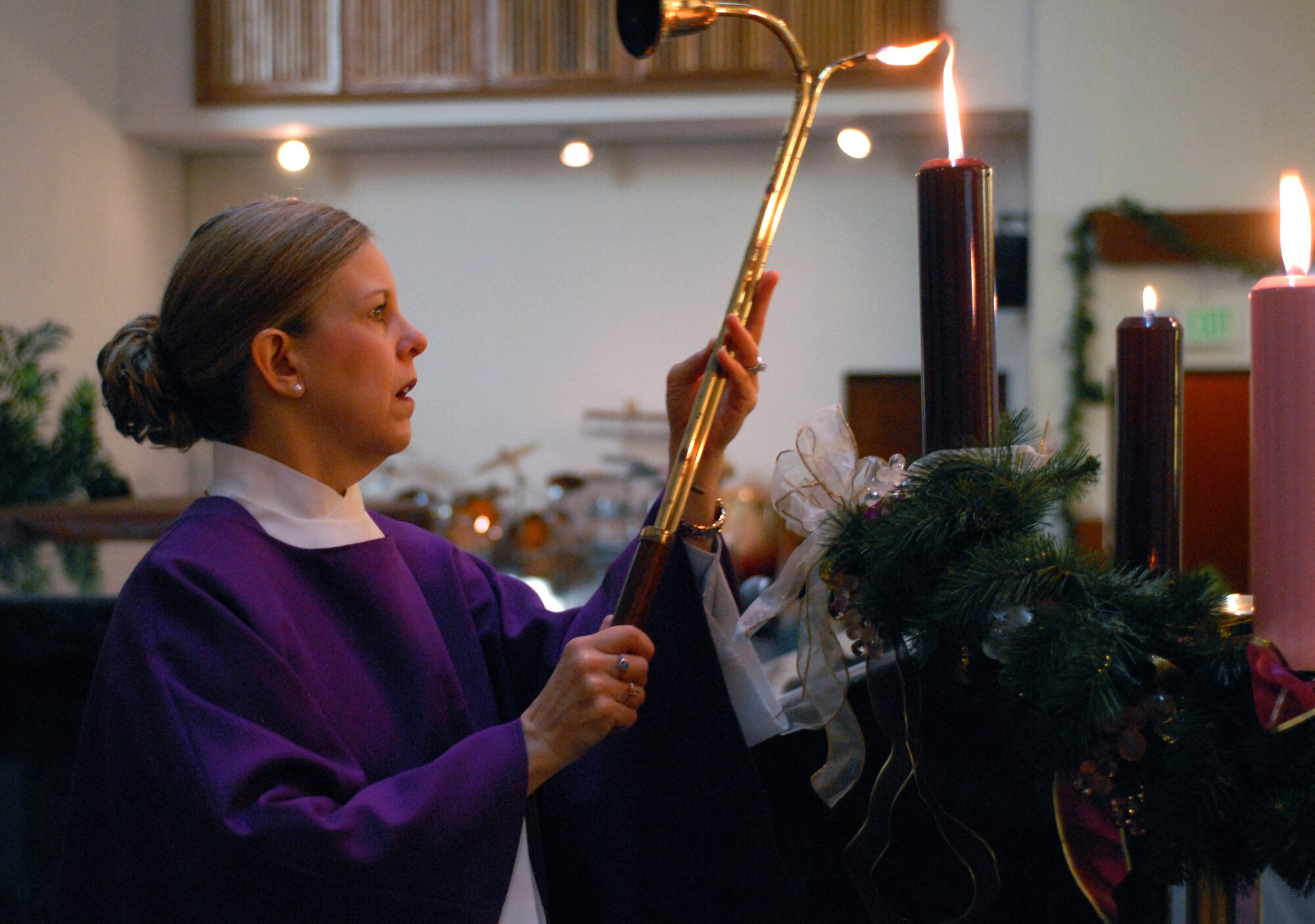 Ch. (Maj.) Christine Blice-Baum lights advent candles in the chapel at Joint Base Pearl Harbor-Hickam, Hawaii, Dec. 17, 2010. She holds a doctorate in church music and obtained her license to teach yoga after practicing personally and leading sessions while deployed to Iraq in early 2010. She now carries the titles of doctor, chaplain, major, misses, and (registered yoga teacher) RYT200, depending on what role she fills at any given time.(U.S. Air Force photo/Staff Sgt. Carolyn Viss)