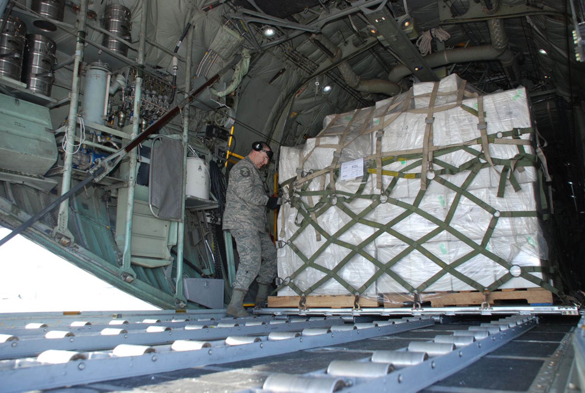Master Sgt. Daniel Witt, 42nd Aerial Port Squadron, secures humanitarian cargo aboard a C-130 Hercules. The cargo, comprising medical supplies for the people of Afghanistan, was part of a Denton humanitarian project. (US Air Force photo/Master Sgt. Andrew Biscoe)