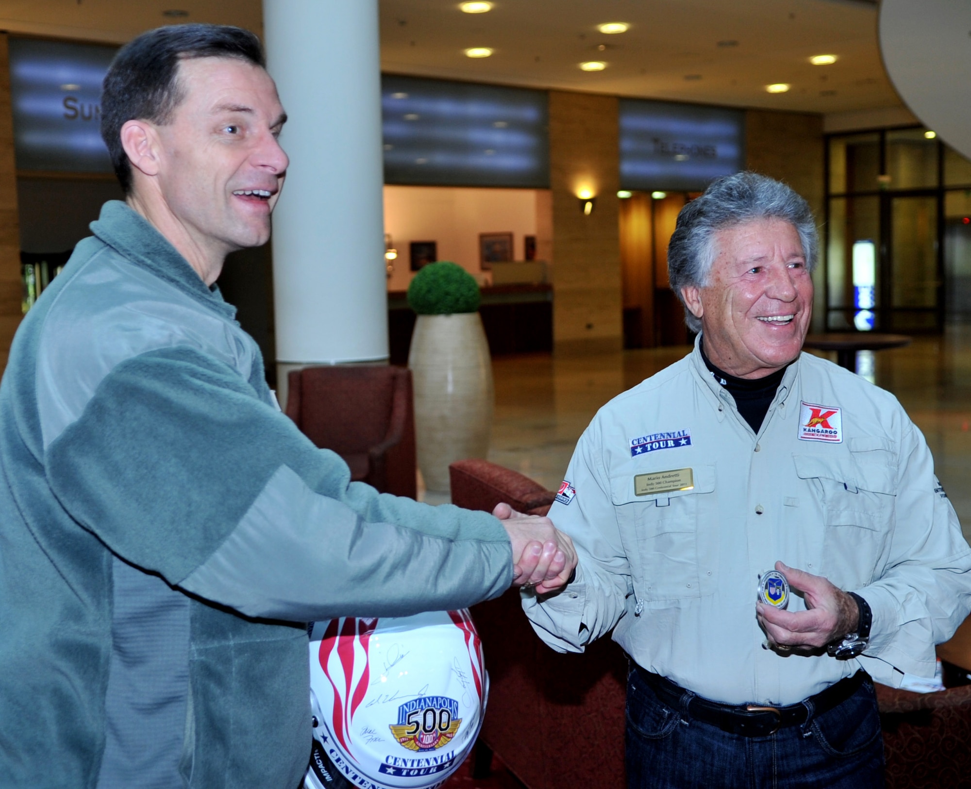 U.S. Air Force Brig. Gen. Mark Dillon, 86th Airlift Wing commander, presents a coin to Mario Andretti, Indy 500, Daytona 500, and Formula 1 champion, during the Indy 500 Centennial Tour, Ramstein Air Base, Germany, Jan. 14, 2011. The Indy 500 Centennial tour brings Indy racing teams to Europe and the Middle East over a 10 day tour to honor and boost morale for service members and their families. (U.S. Air Force photo by Senior Airman Caleb Pierce)