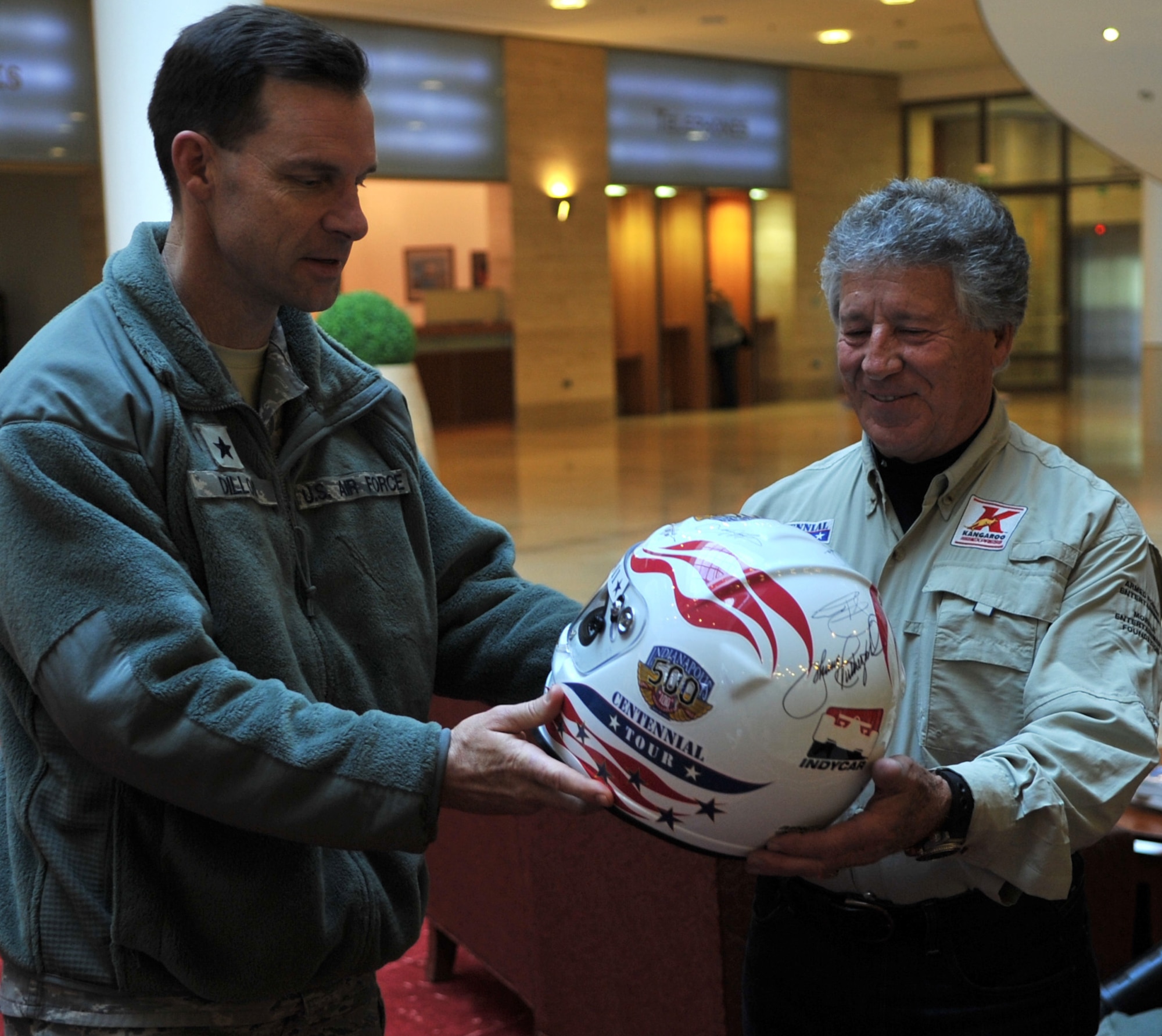U.S. Air Force Brig. Gen. Mark Dillon, 86th Airlift Wing commander, receives an autographed helmet from Mario Andretti, Indy 500, Daytona 500, and Formula 1 champion, during the Indy 500 Centennial Tour, Ramstein Air Base, Germany, Jan. 14, 2011. The Indy 500 Centennial tour brings Indy racing teams to Europe and the Middle East over a 10 day tour to honor and boost morale for servicemembers and their families. (U.S. Air Force photo by Senior Airman Caleb Pierce)

