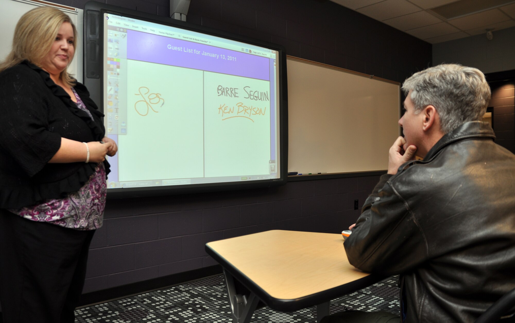 Lori Cargile demonstrates a variety of the capabilities a “smart board” offers teachers while Col. Barre Seguin, 14th FTW commander, watches during a tour of the new Columbus Middle School Jan. 13. Ms. Cargile is the academic coach and International Baccalaureate coordinator for Columbus High School. (U.S. Air Force photo/Staff Sgt. Jacob Corbin).
