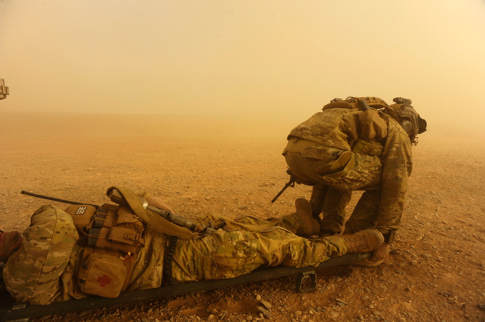 Captain Nick Morgans and Tech. Sgt. Anthony Wood (not pictured) prepare to move a simulated casualty to load him onto an HH-60G Pave Hawk during a mass-casualty scenario Dec. 24, 2010, near Kandahar, Afghanistan. The scenario was planned as part of Sgt. Wood's qualification to become an element leader. Captain Morgans and Sergeant Wood are both assigned to the 46th Expeditionary Rescue Squadron. (U.S. Air Force Photo/Staff Sgt. Eric Harris)