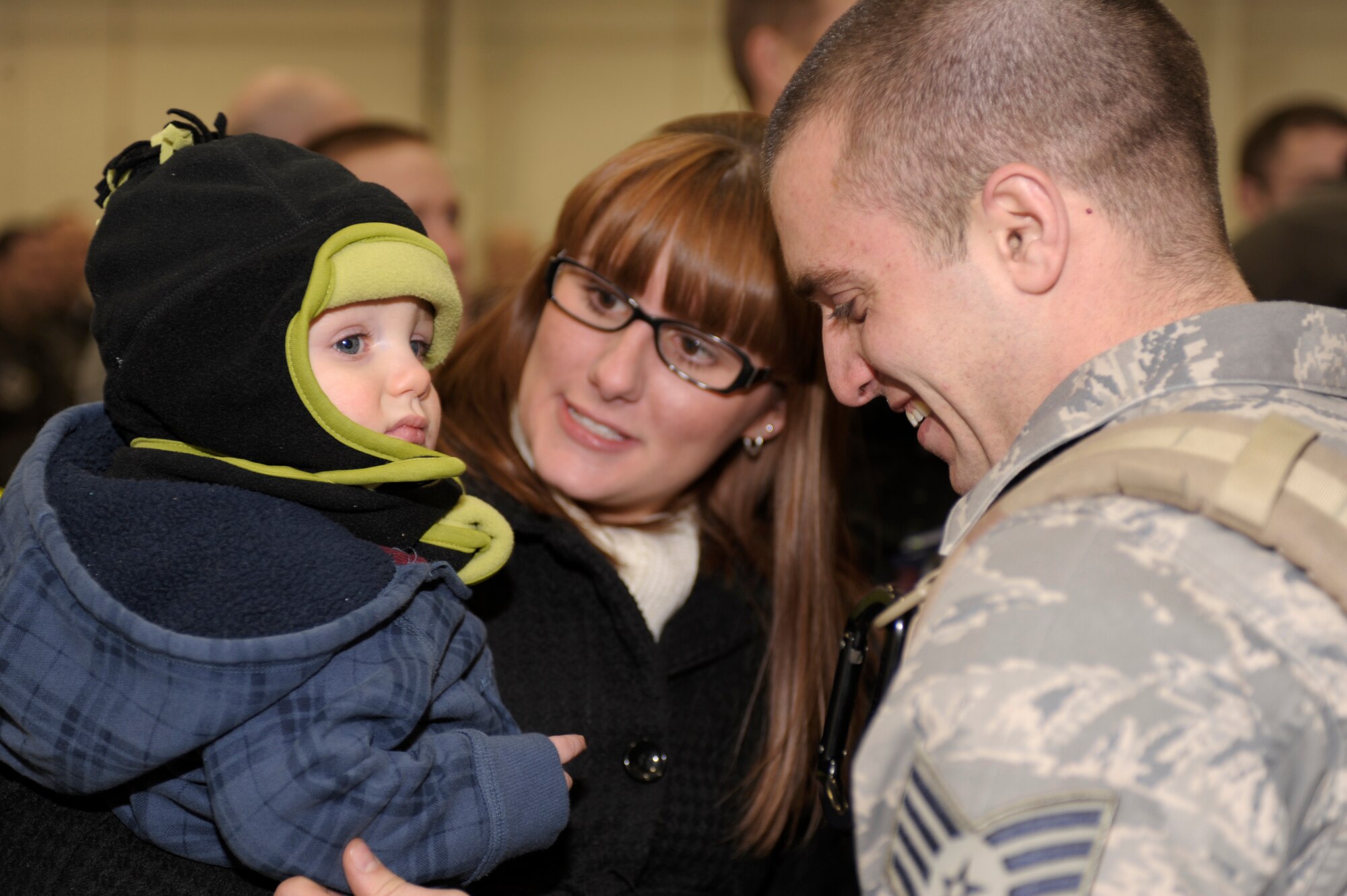 Staff Sgt. Sean Szekeresh, 16th Special Operations Squadron, greets his family,  Kale and Brittany, in Hangar 196 following his return from deployment to Cannon Air Force Base, N.M., Jan. 10, 2011. Sergeant Szekeresh's family joined  other  families and friends who gathered in the hanger to welcome their loved ones home. (U.S. Air Force Photo by Airman Ericka Engblom)